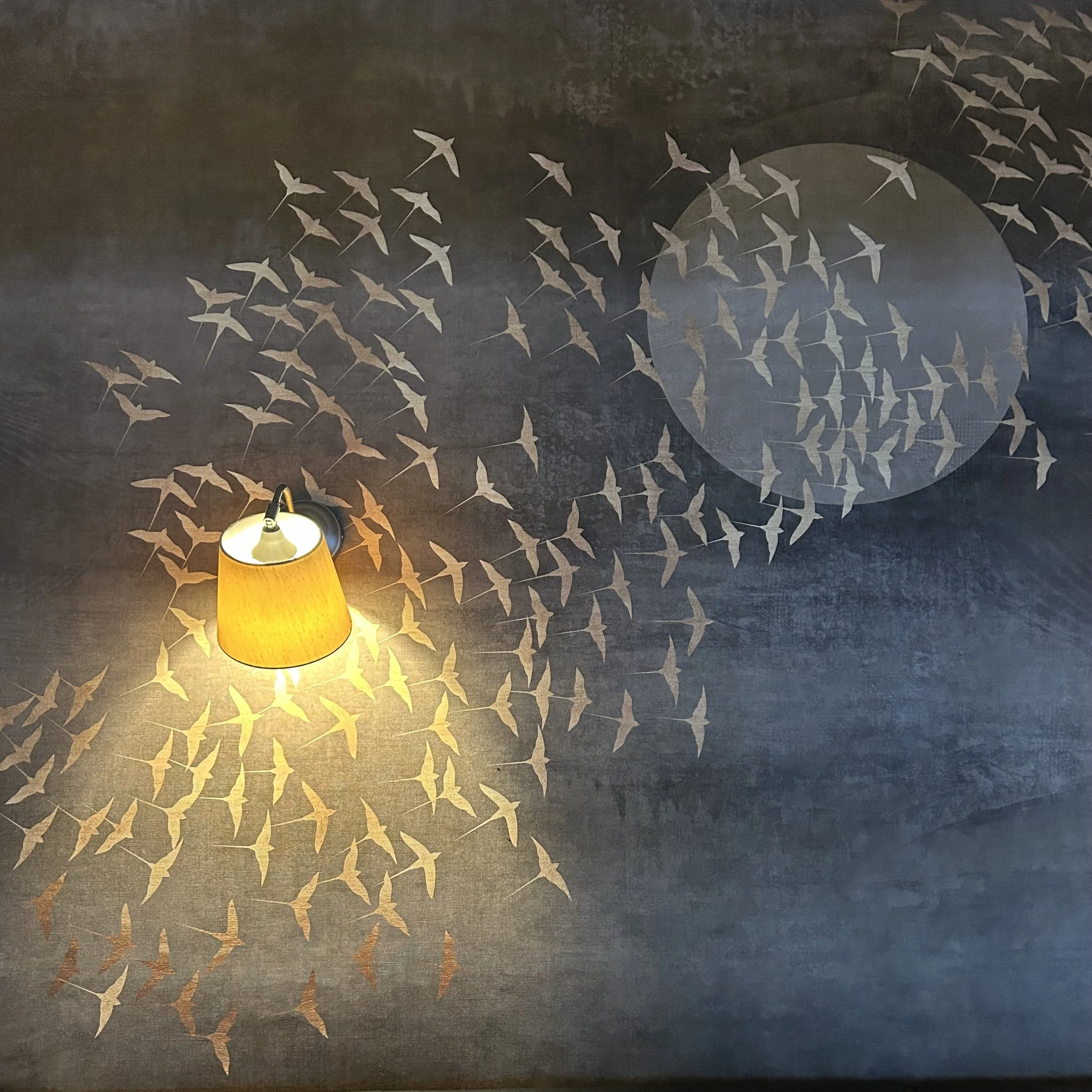 Tapete in blau und gold mit Vögeln udn Wandlampe