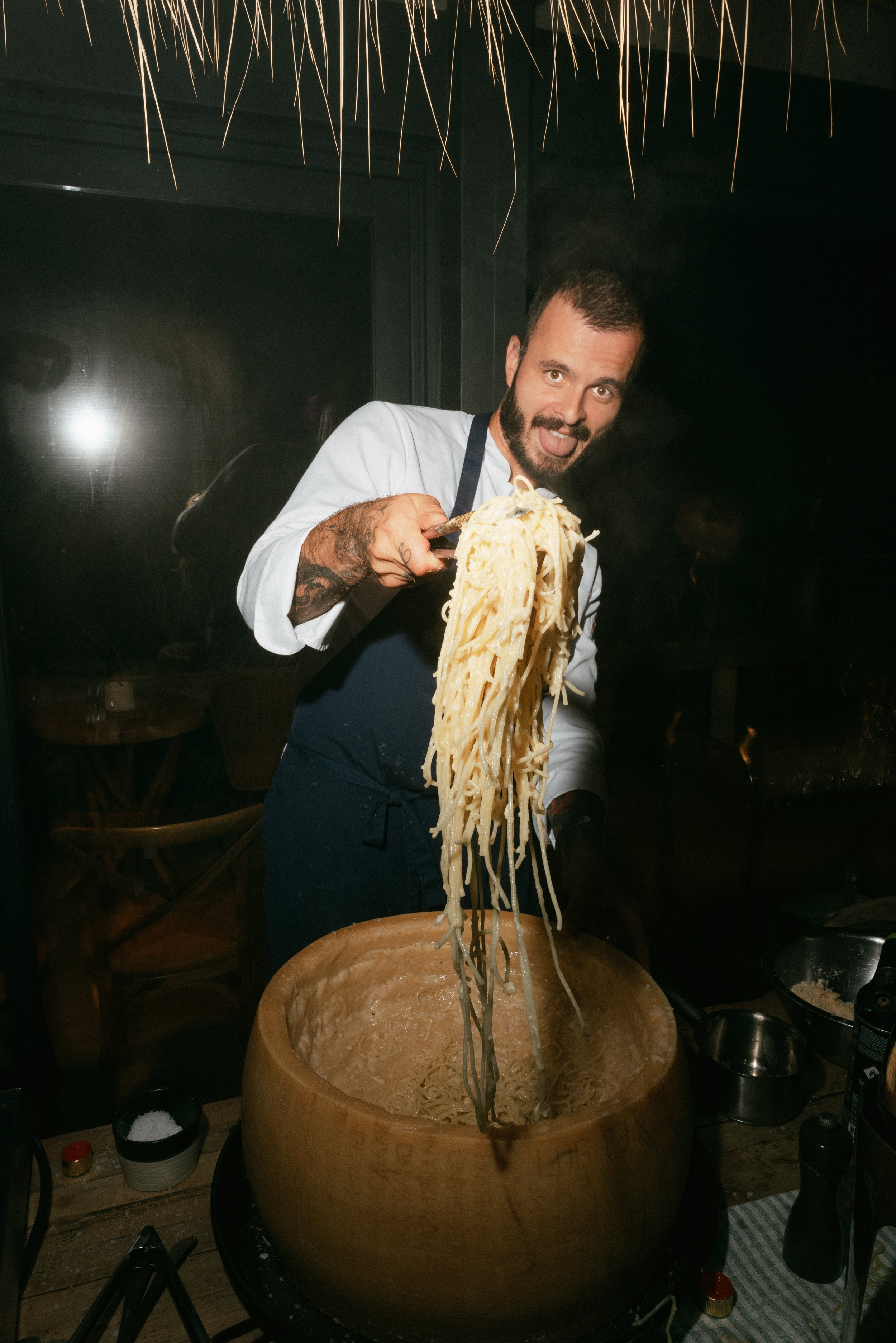 Chef preparing pasta with cheese wheel at restaurant