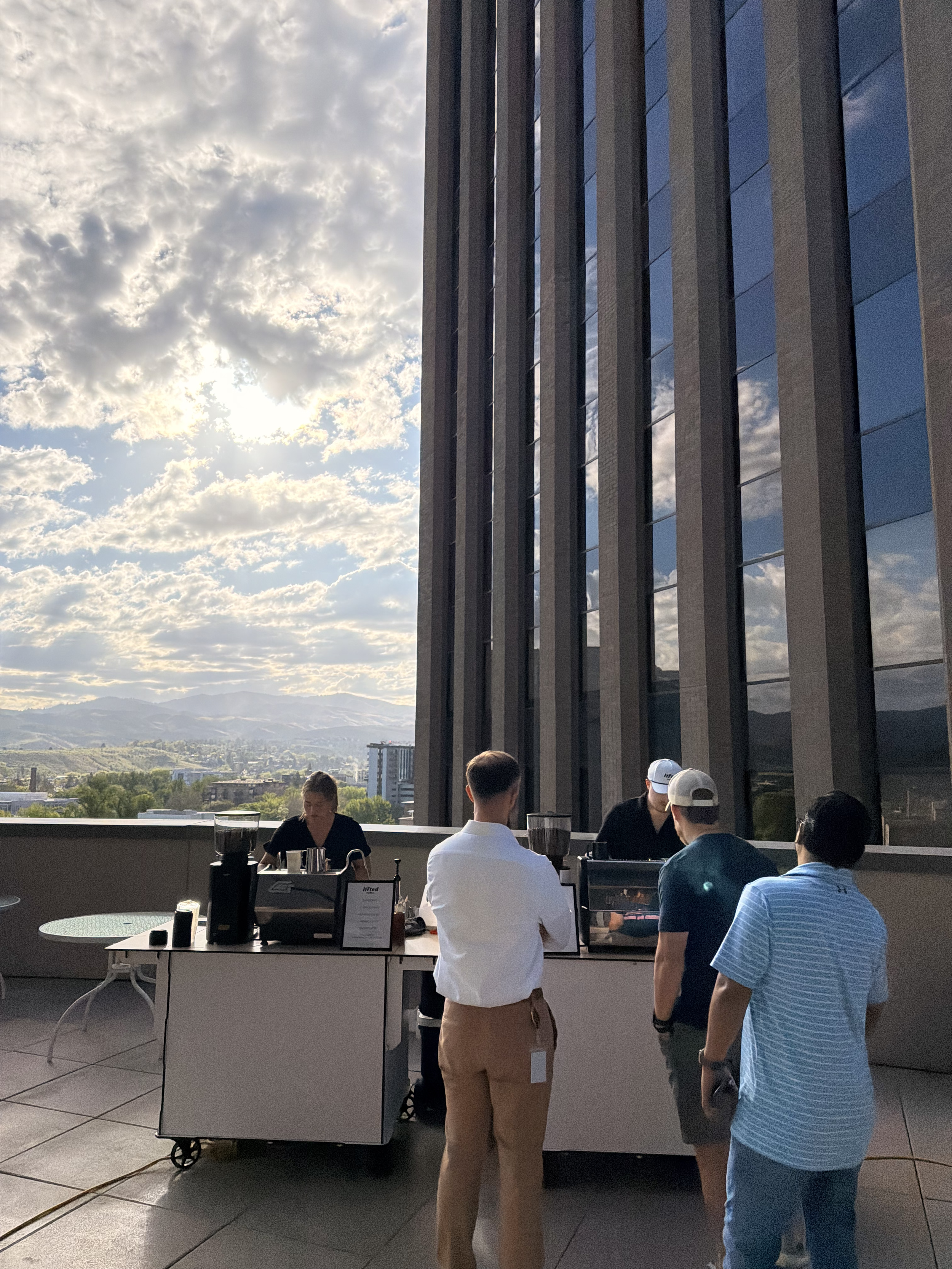 Lifted Coffee Cart barista serving corporate event guests on a rooftop in downtown Boise Idaho with city and mountain views