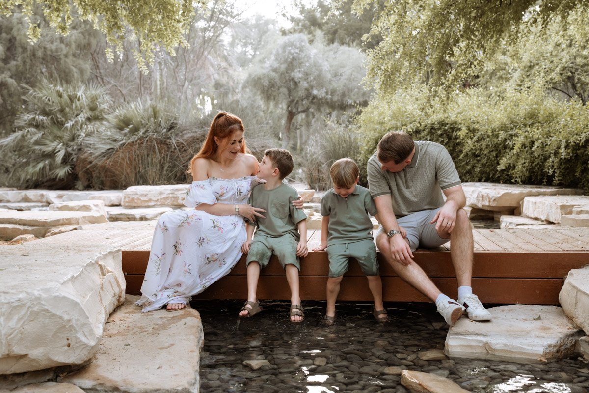 family posing for pictures in umm al emarat park