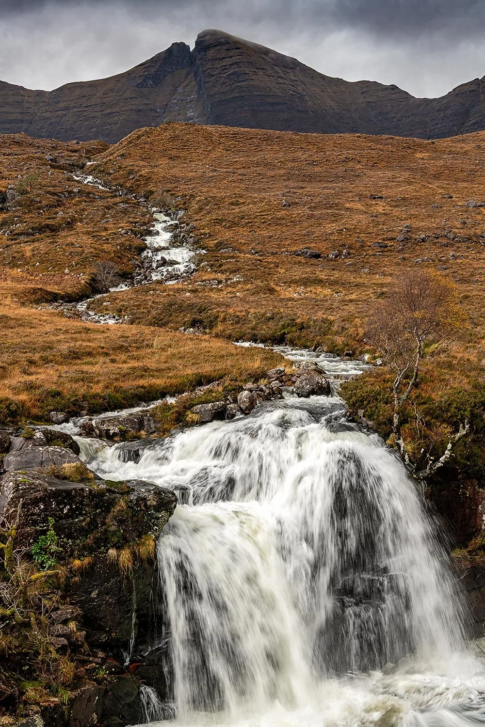 A stunning waterfall with the dramatic backdrop of Beinn Alligin in Torridon Scotland.