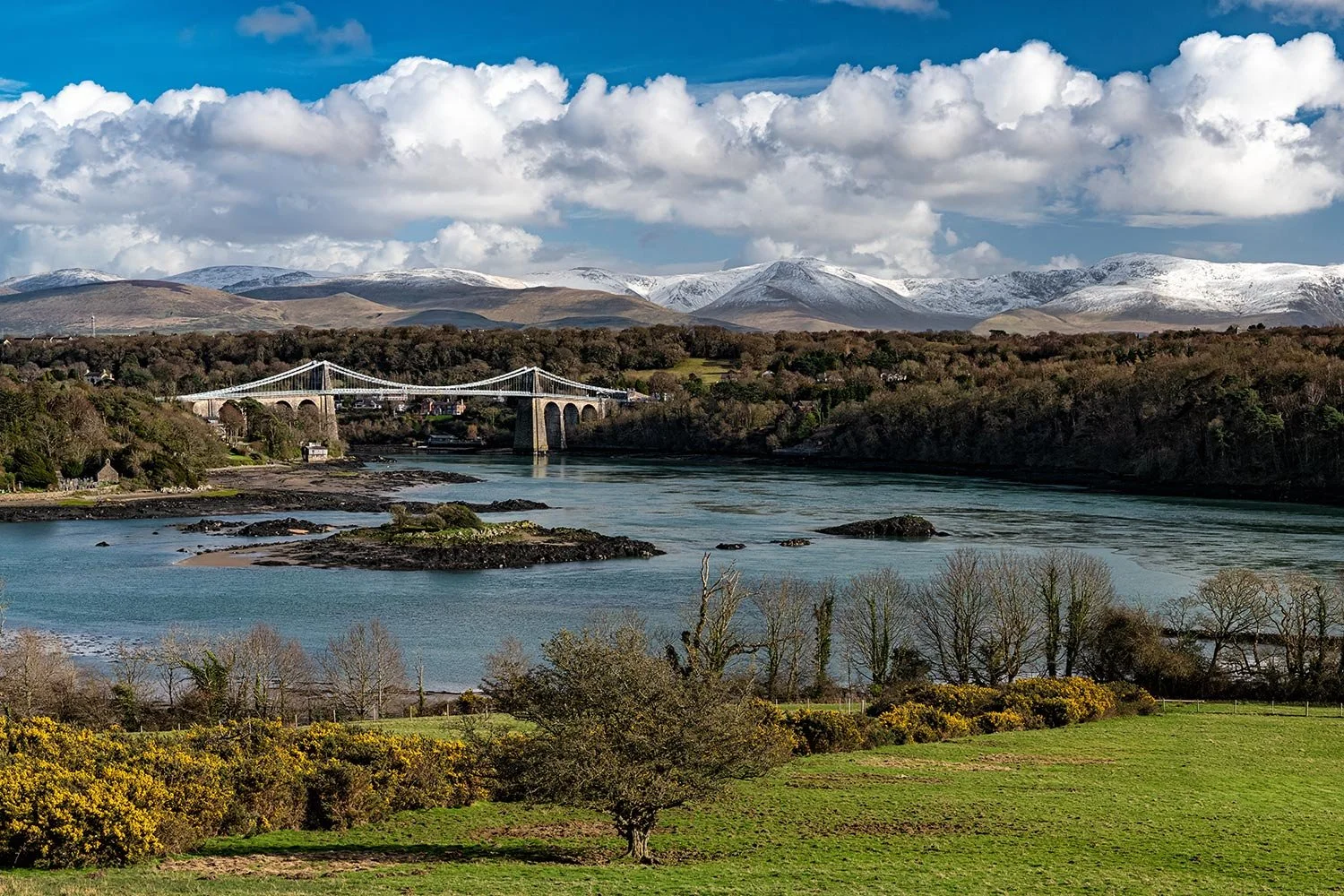 The Menai Bridge and Eryri Snowdonia mountains from Anglesey.