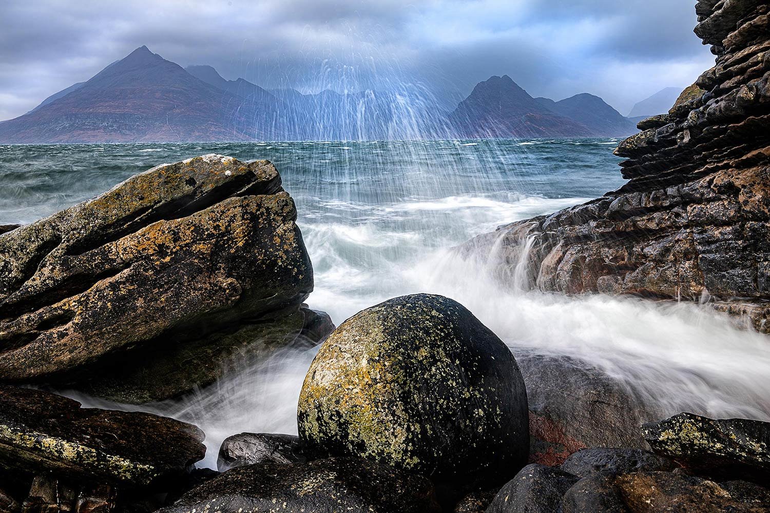 A stormy sea at Egol crashes over the famous Elgol boulder