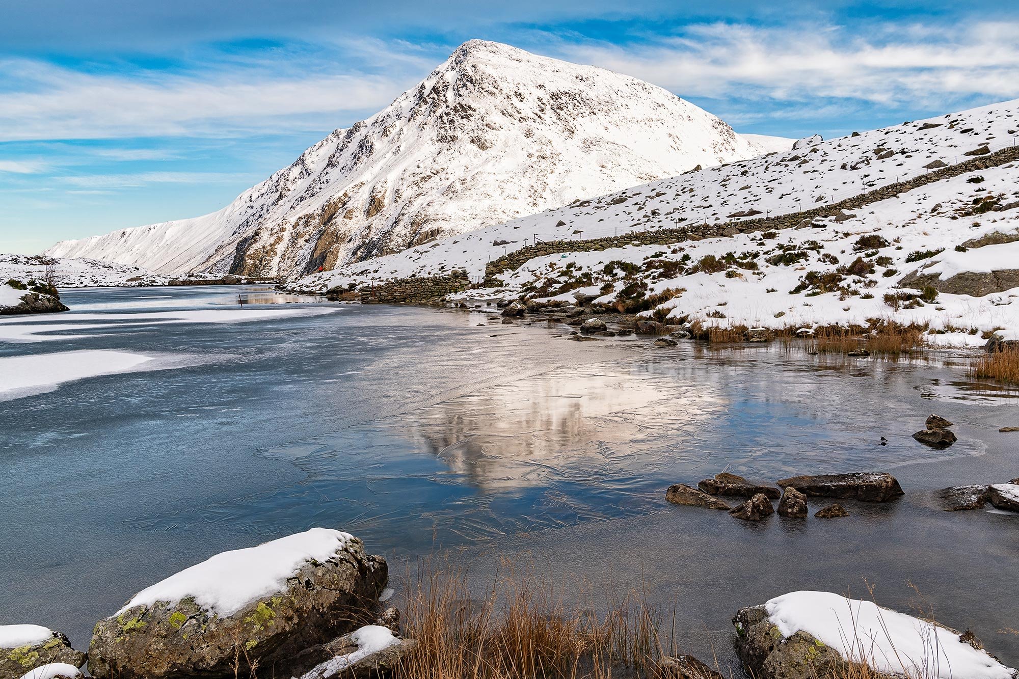 Icy reflections of Pen Yr Ole Wen in frozen Llyn Idwa