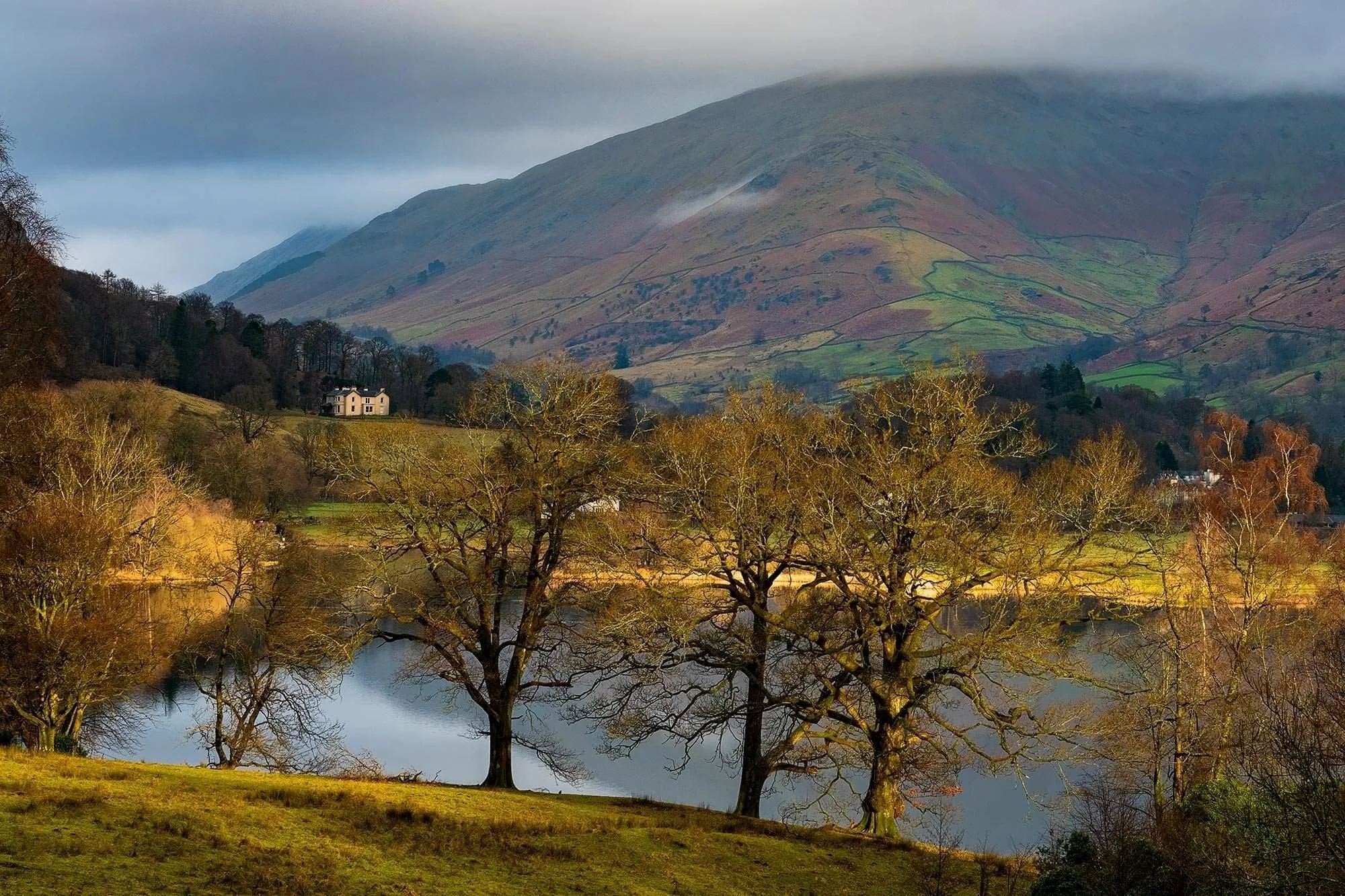 Sun-drenched morning light on Grasmere with Fairfield backdrop, Lake District.