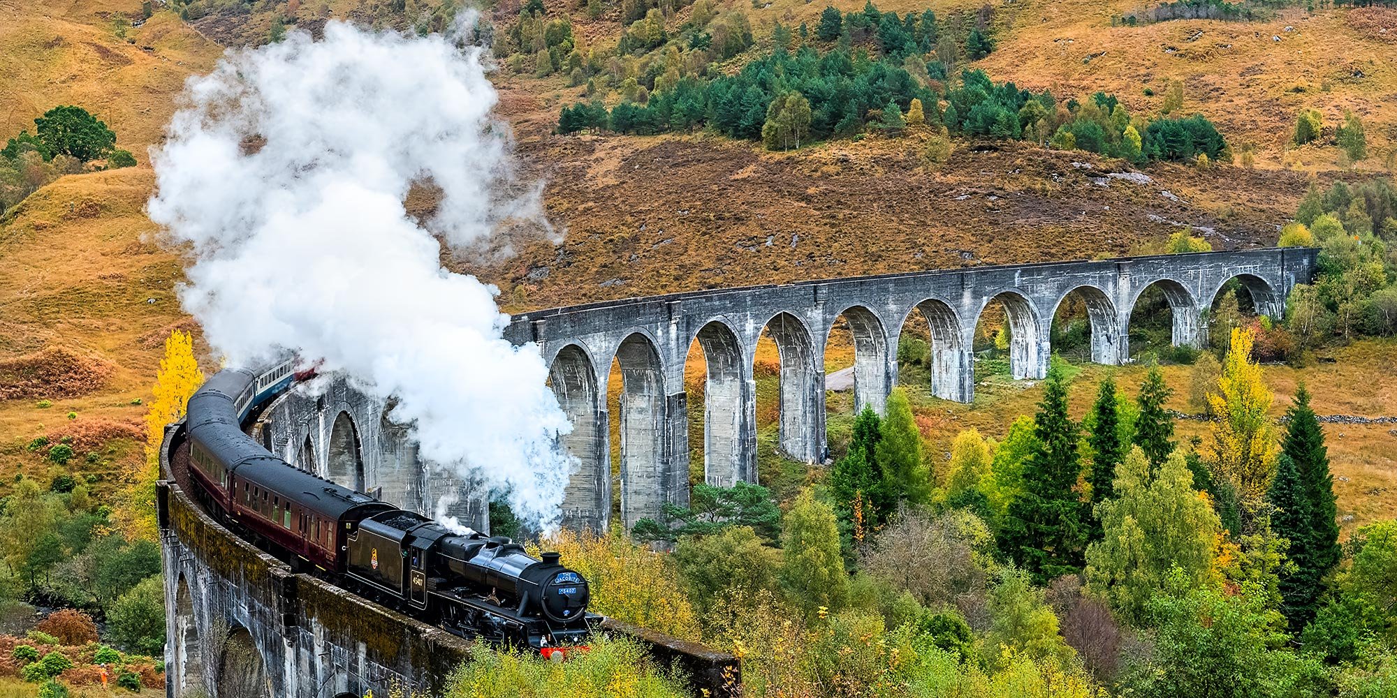 The famous Jacobite steam train of Harry Potter fame passing over the Glenfinnan viaduct near Fort William