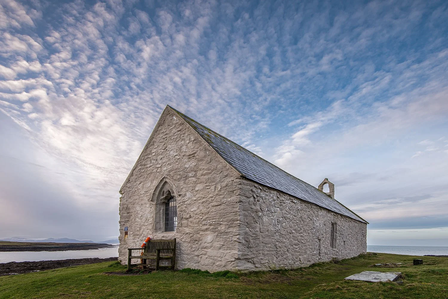 St Cwyfan Church Aberffraw on a beautiful summer day on Anglesey. rocky outcrop near Aberffraw, Anglesey, surrounded by the incoming tide. (Copy)