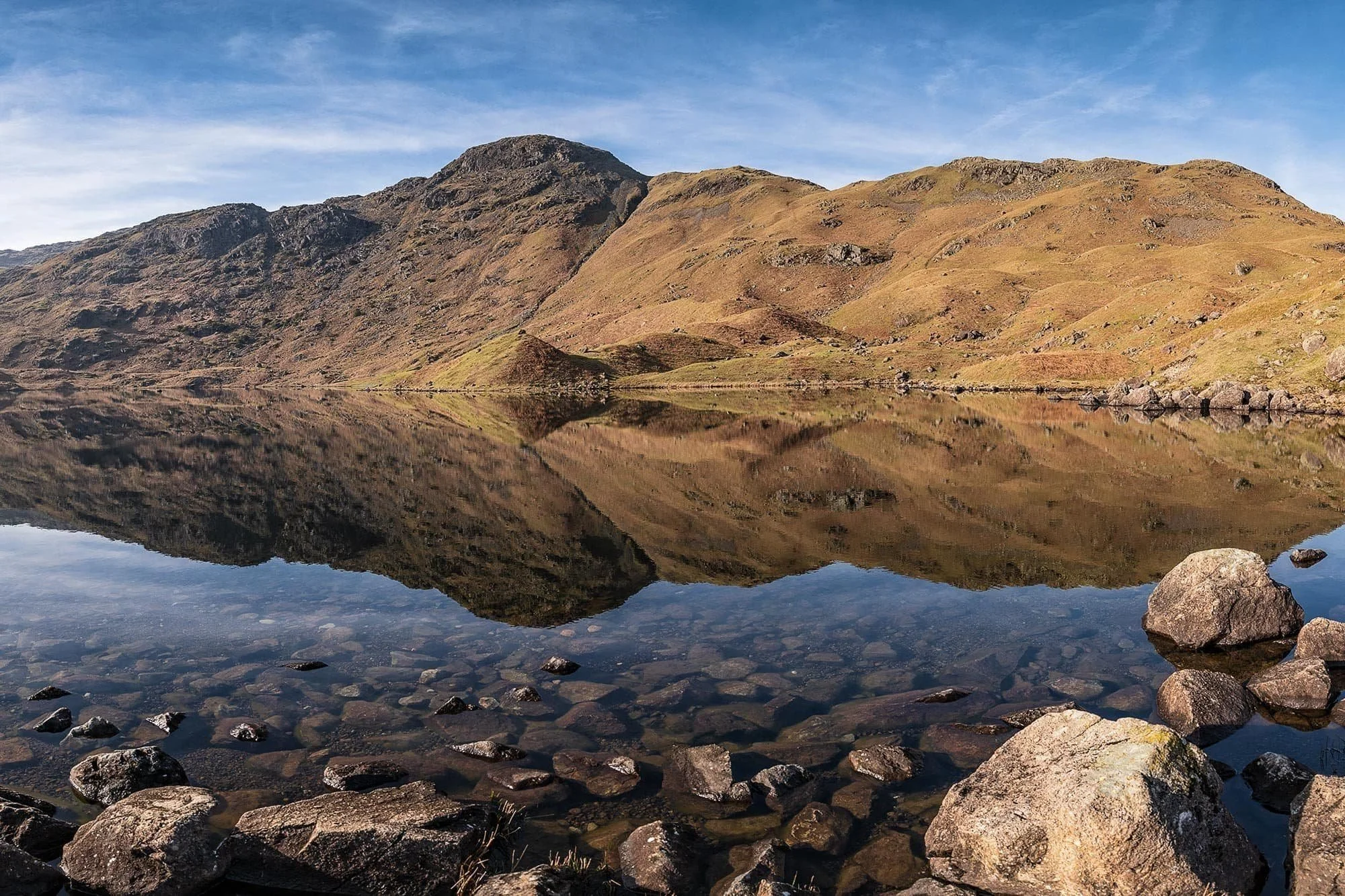 Autumn colours mirrored in the surface of Easedale Tarn, Lake District.