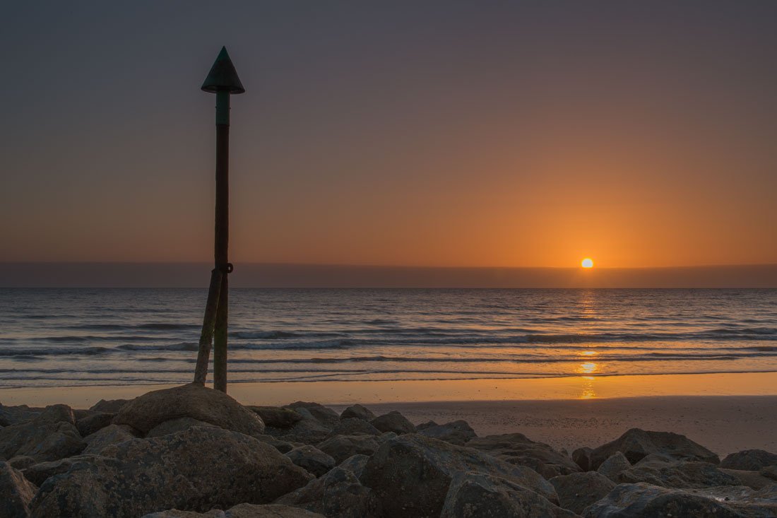 The sun setting from the beach at Dinas Dinlle