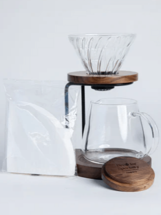 Hario Walnut Drip Stand Set for V60 pour-over brewing, including glass dripper, glass server, walnut stand, and paper filters.