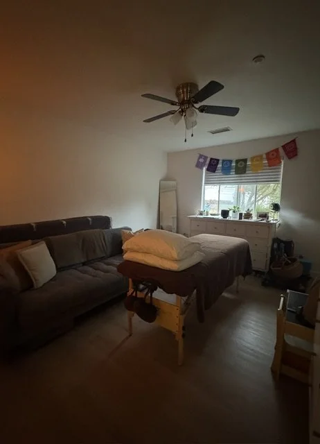 A home bedroom turned healing space with a colorful banner hanging above the window.