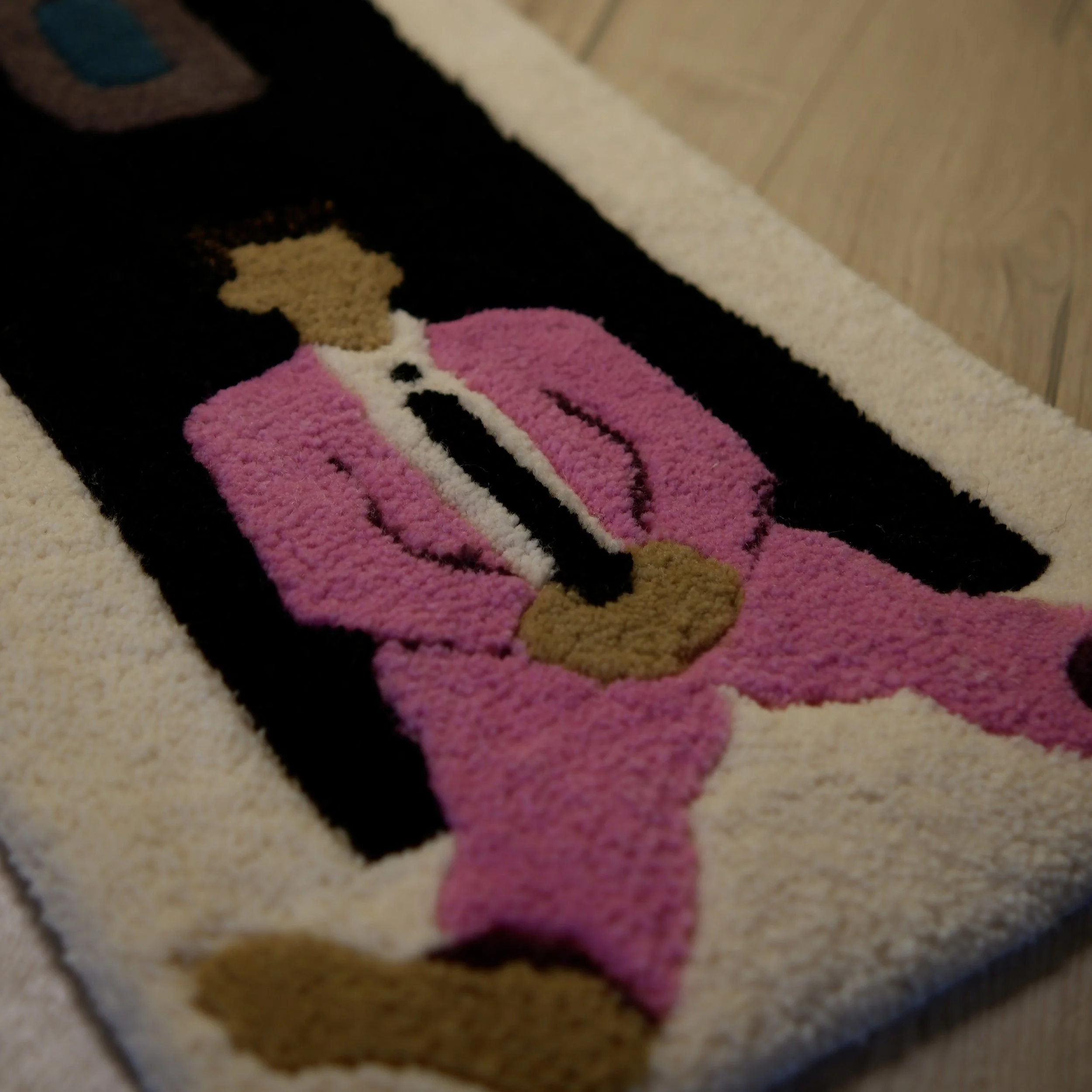 A decorative door mat featuring a cartoon princess in a pink dress with a golden hairdo, set against a black background.