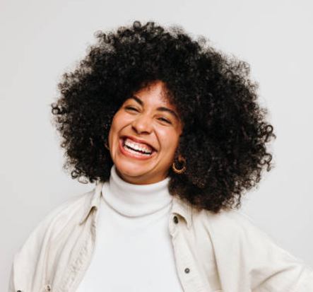 A woman smiles, representing a potential client for affirming holistic trauma therapy by therapist Amy Bowen in Hyde Park, Utah.