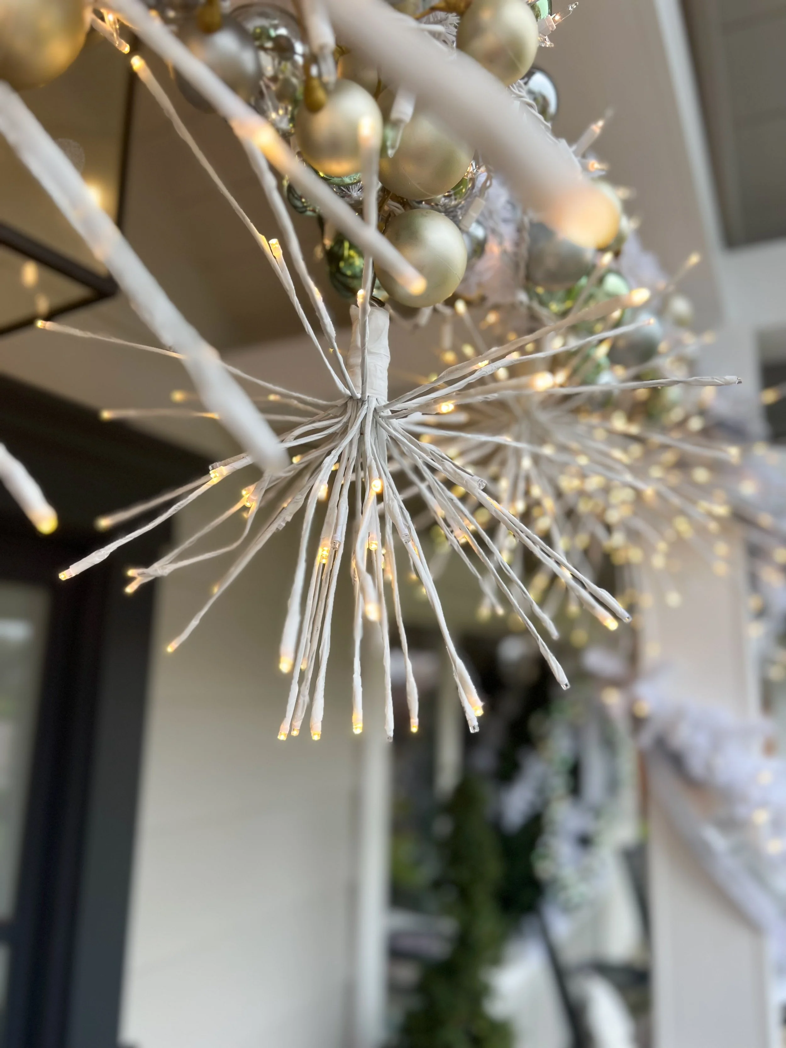 Close-up of decorative string lights and ornaments with metallic balls.