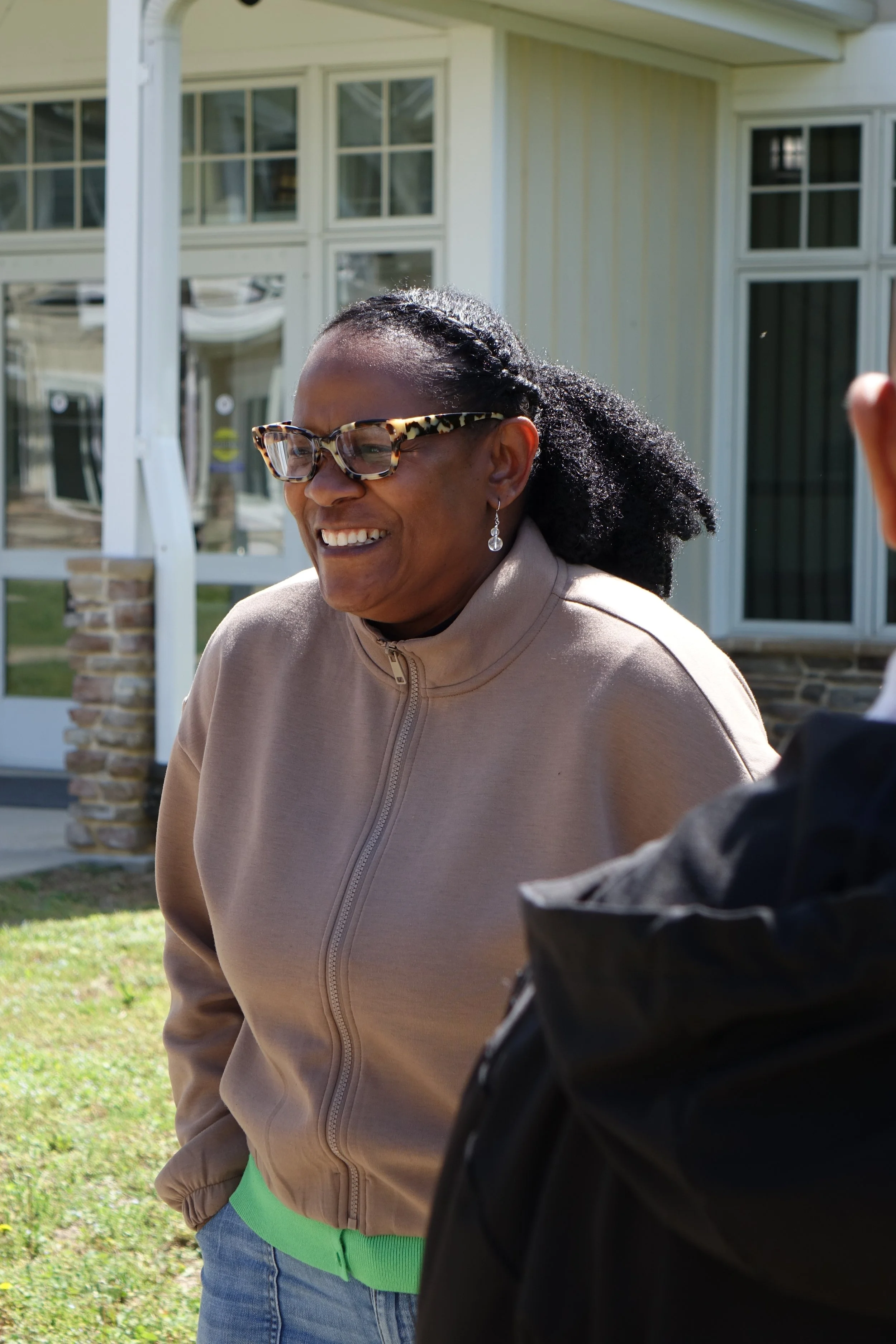 Woman engaged in convo, smiling and laughing with her partner.