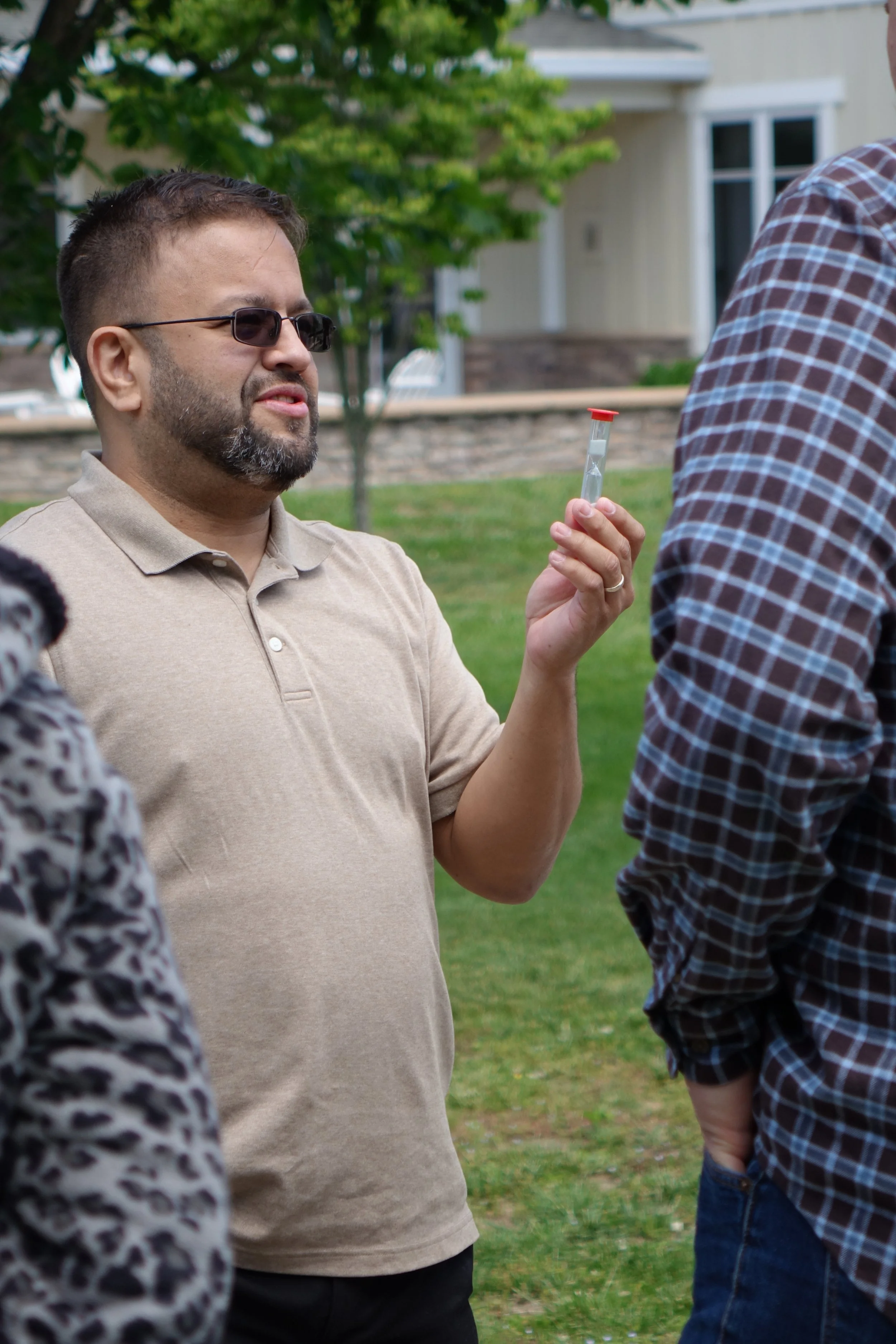 Man holding up a one-minute timer, talking intently with his partner.