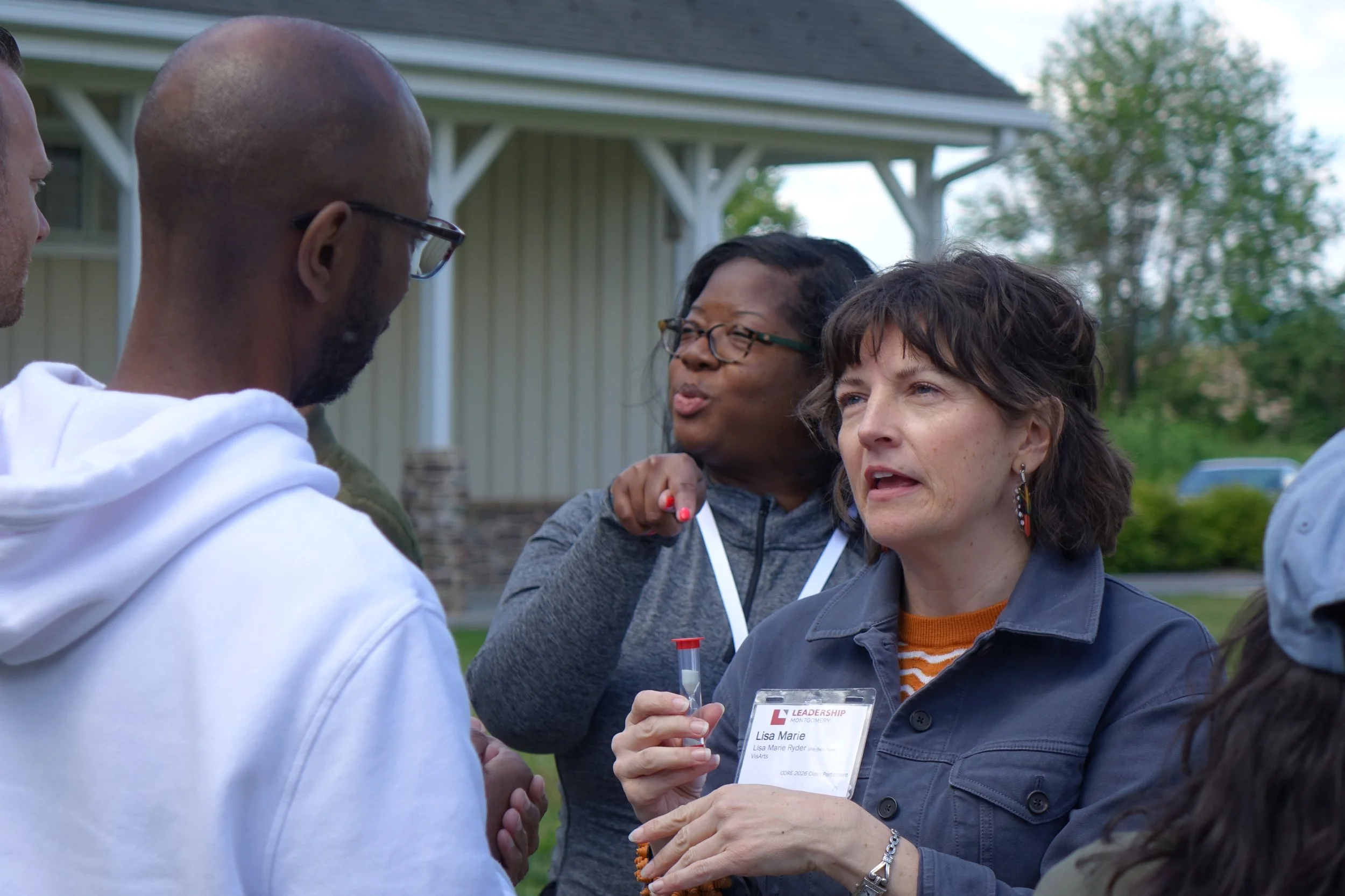 Two women, side-by-side, engaged in speaking to their partners across from them.
