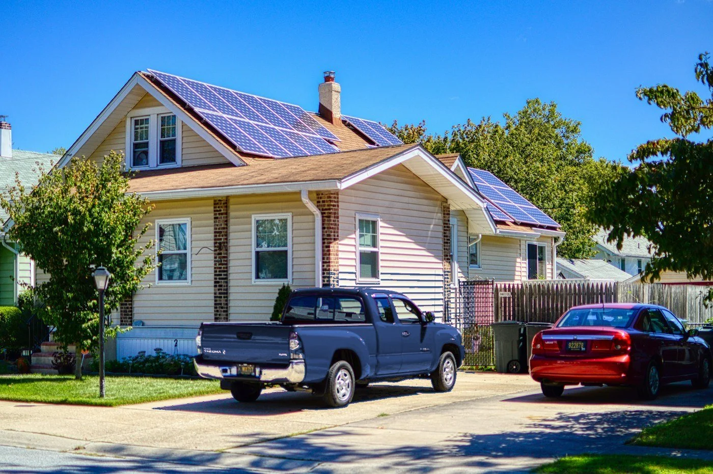 Home with rooftop solar panels and a pickup truck in the driveway