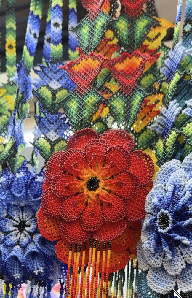 Colorful bead art flowers and butterflies display, with intricate bead patterns and vibrant colors.