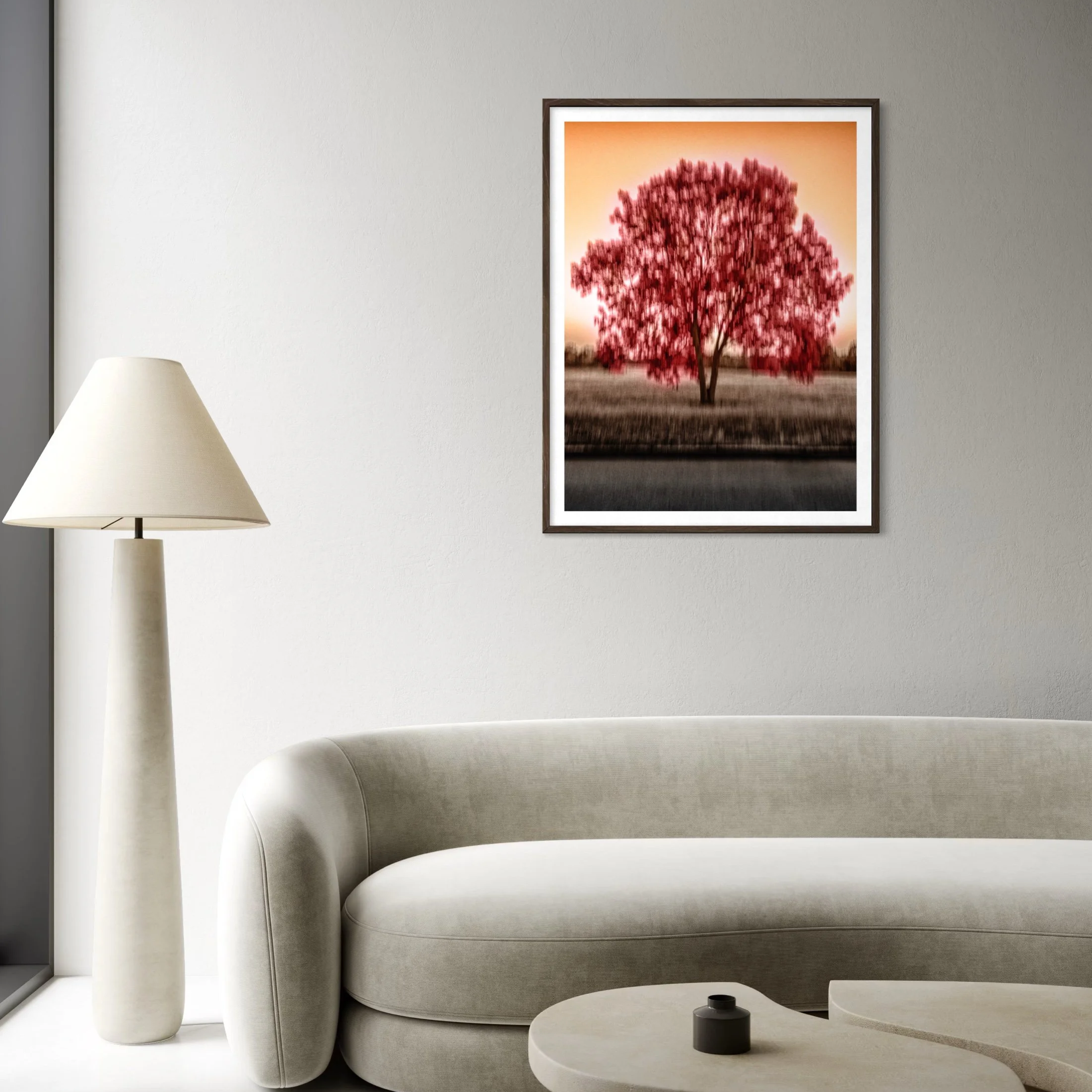 The Tree of Passion, framed crimson abstract art print displayed in a minimalist cream living room with a curved sofa.