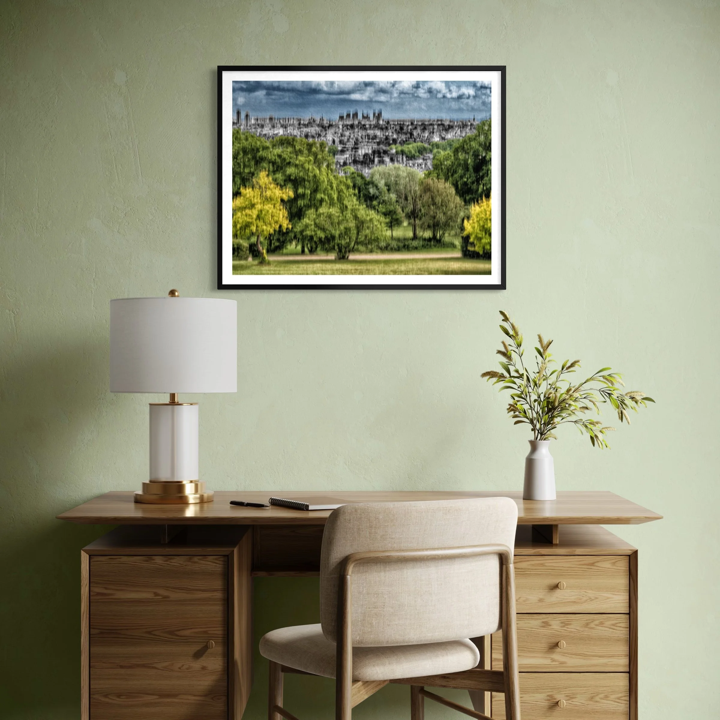Abstract landscape artwork with green trees and a distant skyline displayed above a wooden desk in a calm home office.