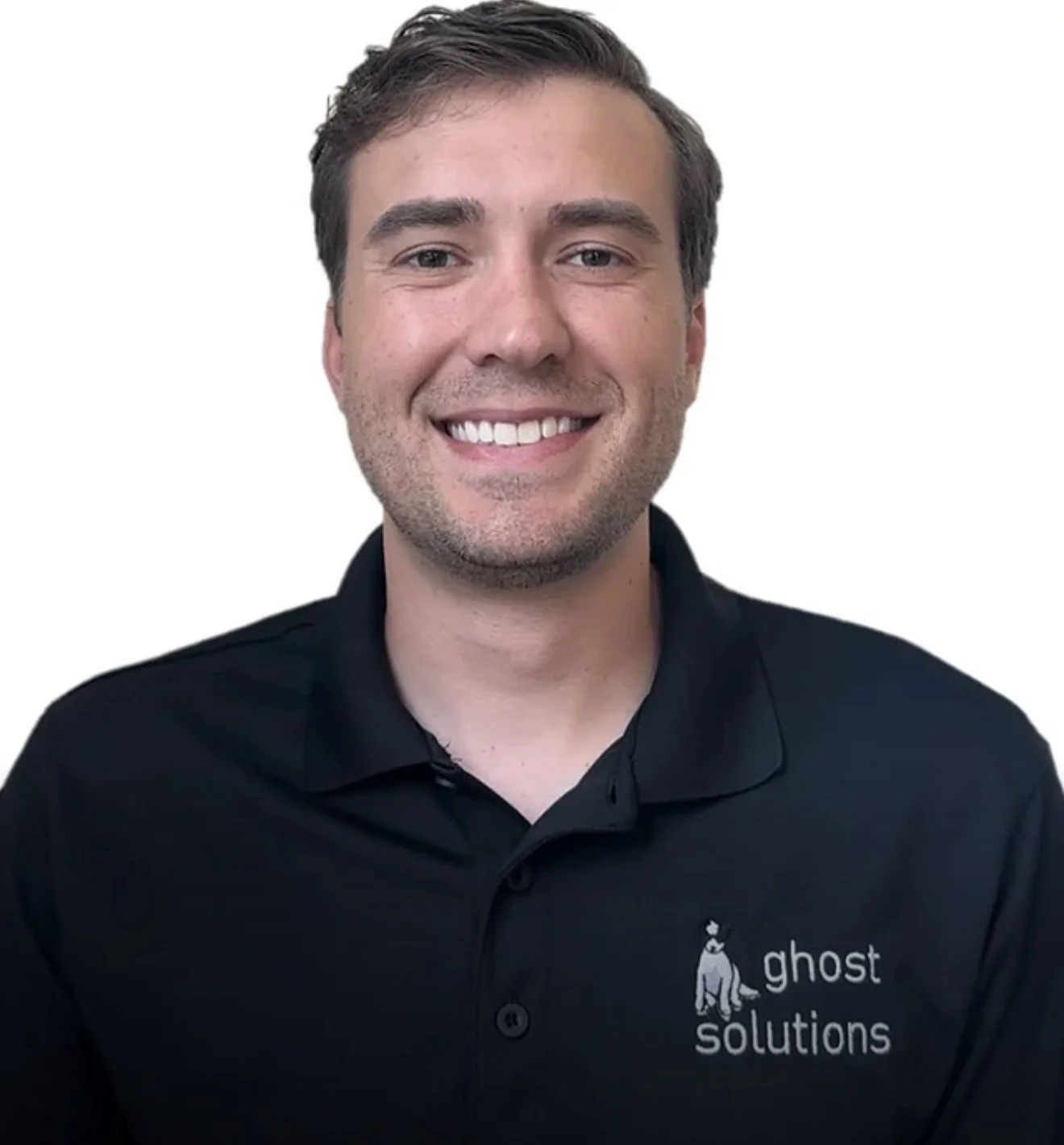 A man with short brown hair, smiling, wearing a black polo shirt with a ghost logo and 'ghost solutions' text.