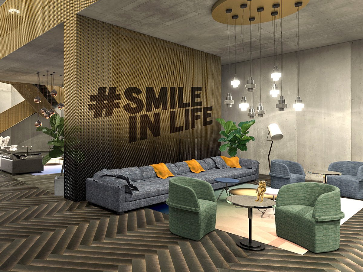Modern hotel lobby with a large gray couch and green armchairs, a small round table with a decorative gold sculpture, a floor lamp, hanging pendant lights, and a wall with a large hashtag sign '#SMILE IN LIFE'.