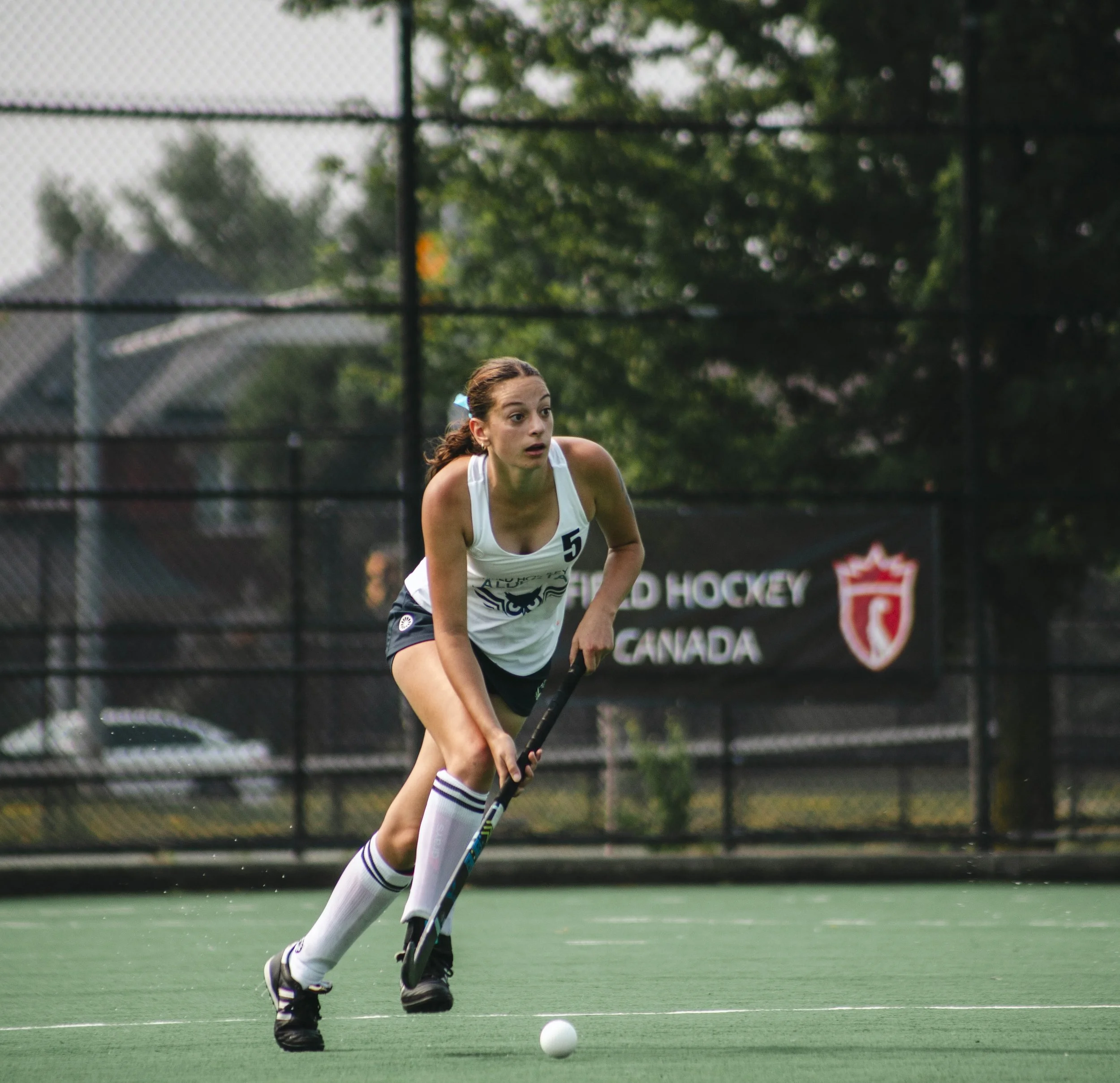 Girls field hockey player 5 for Alberta running with the ball