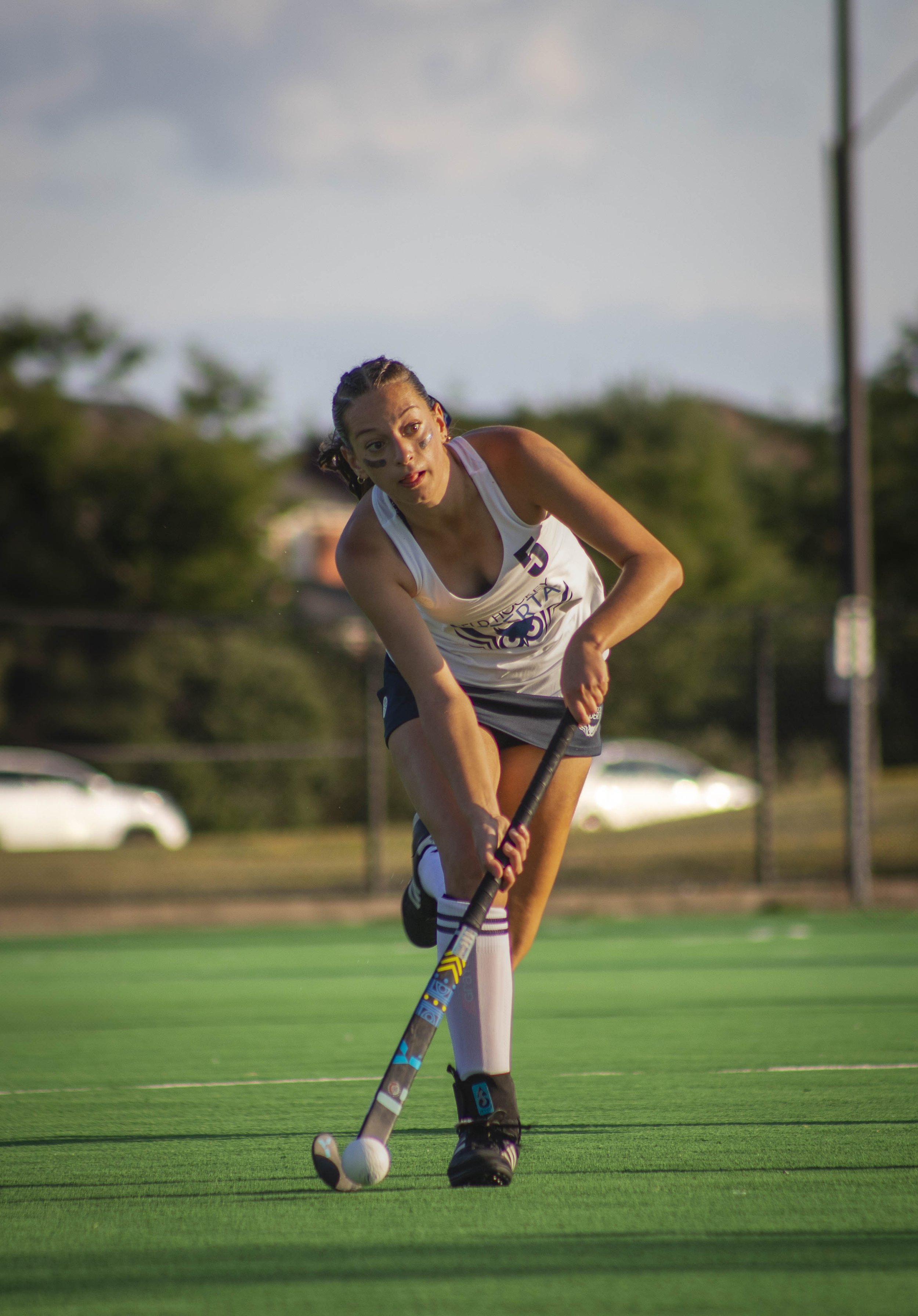 Girls field hockey player 5 for Alberta running with the ball