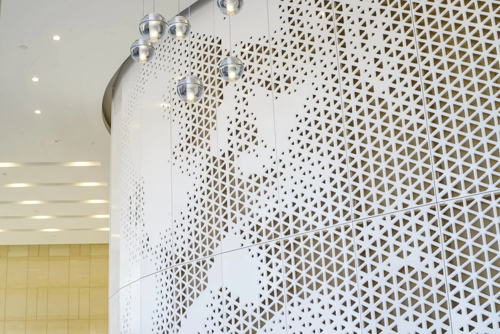 Modern interior with geometric patterned wall and spherical hanging lights