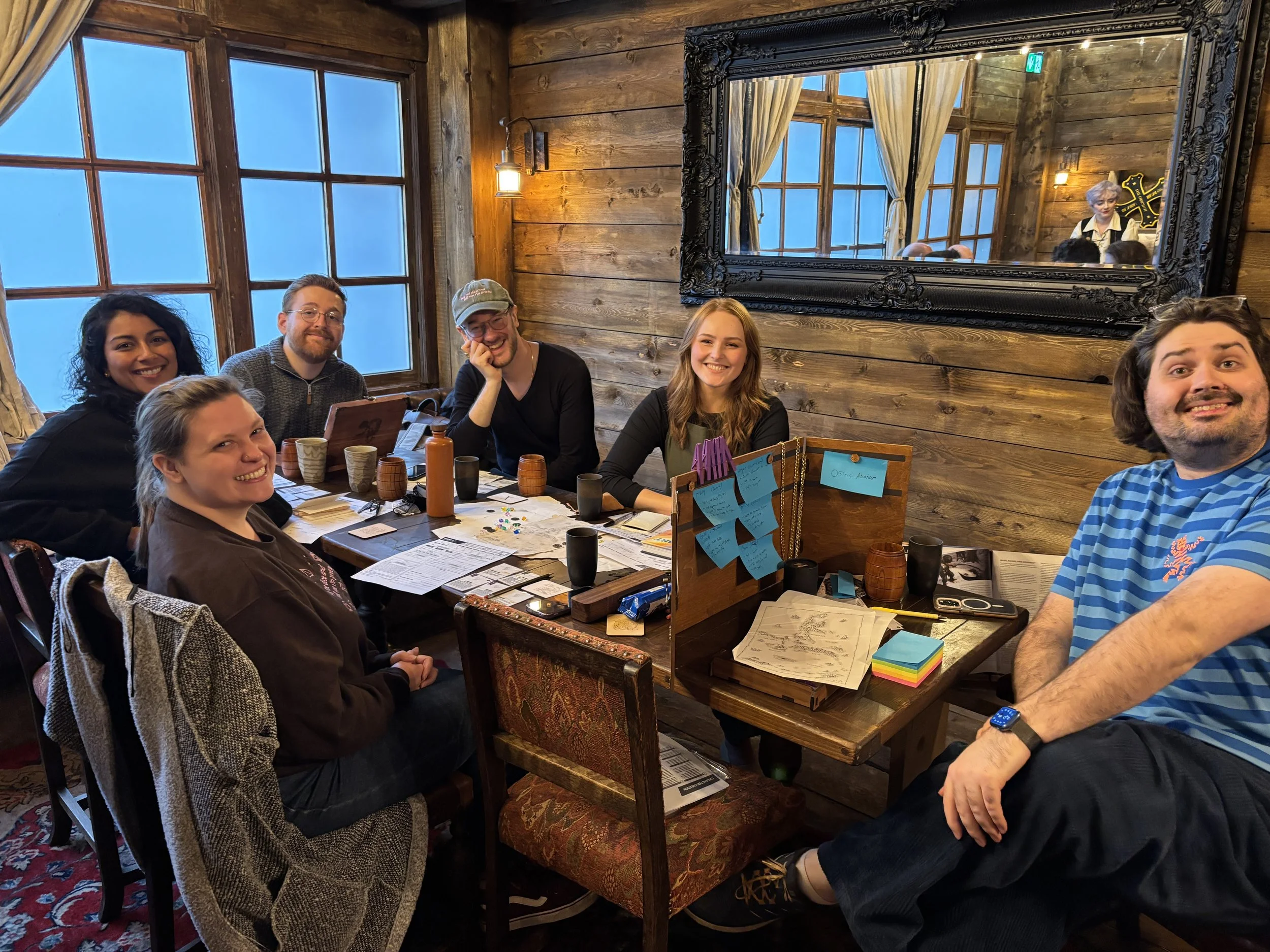 A group of people sitting around a table in a wood-panelled room