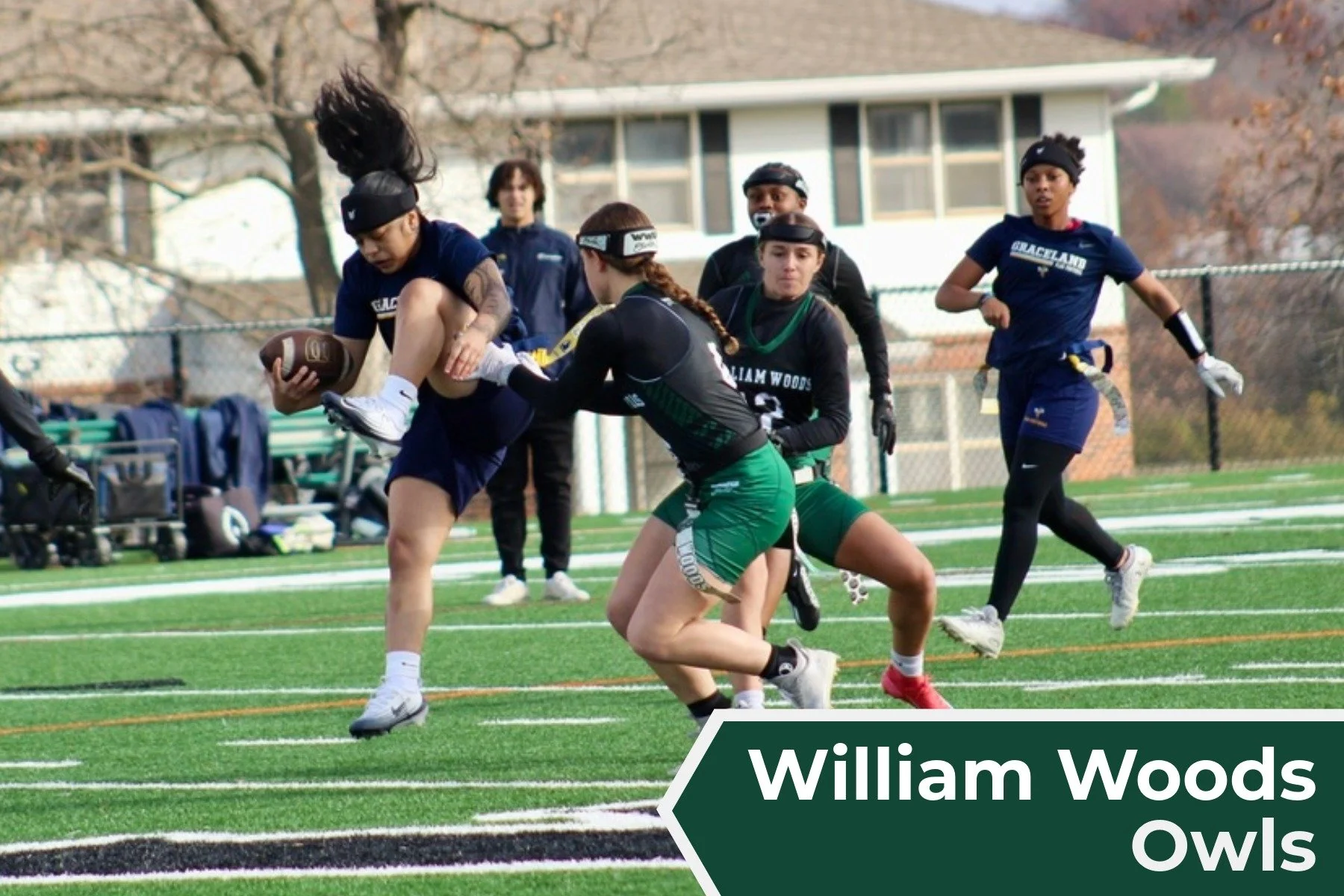Girls playing flag football on a field with coaches and team members watching in the background