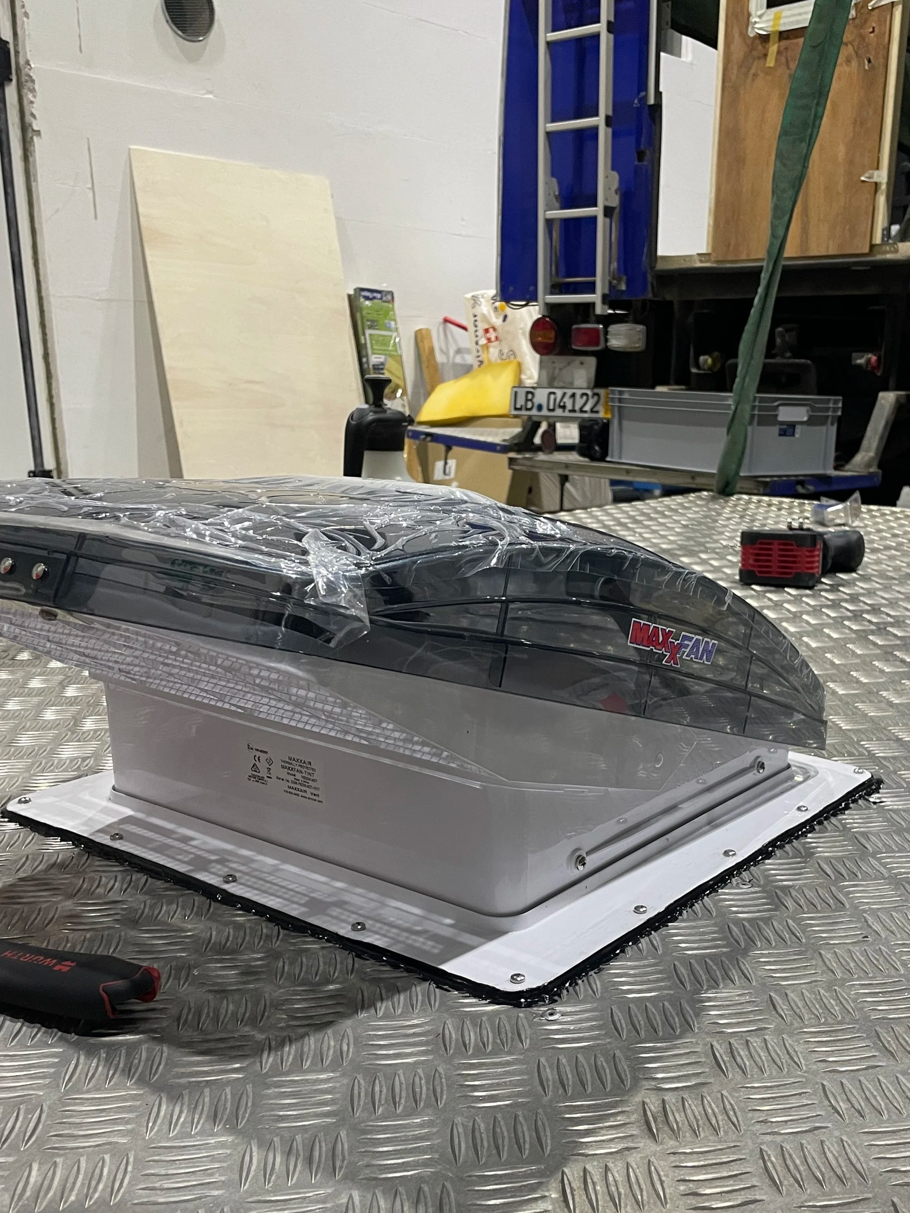 Ein Dachlüfter mit auf einem Fahrzeugdach in einer Werkstatt.