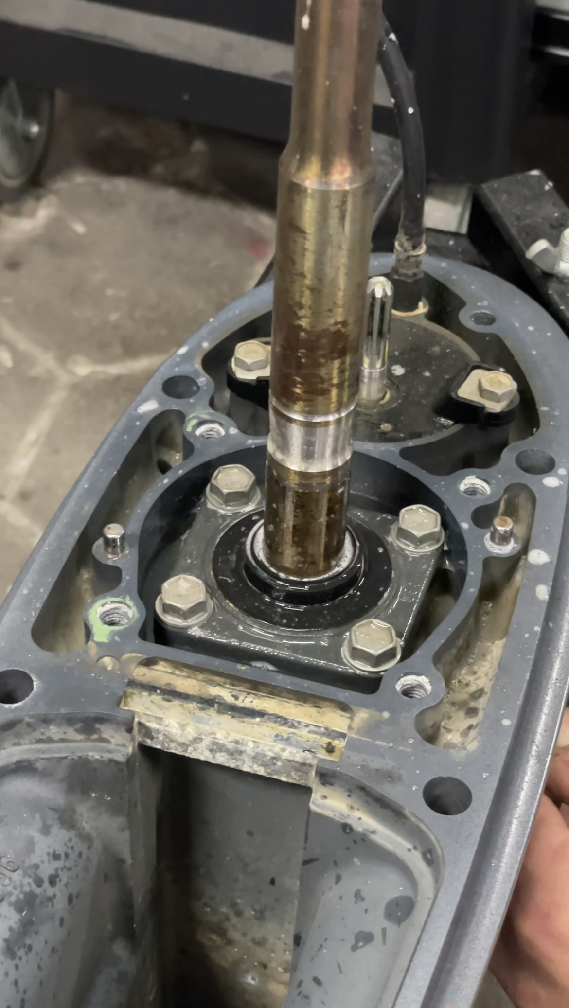 offenes Unterwasserteil mit sichtbaren Wellen und Getriebe, der Teil eines Außenbordmotors ist.