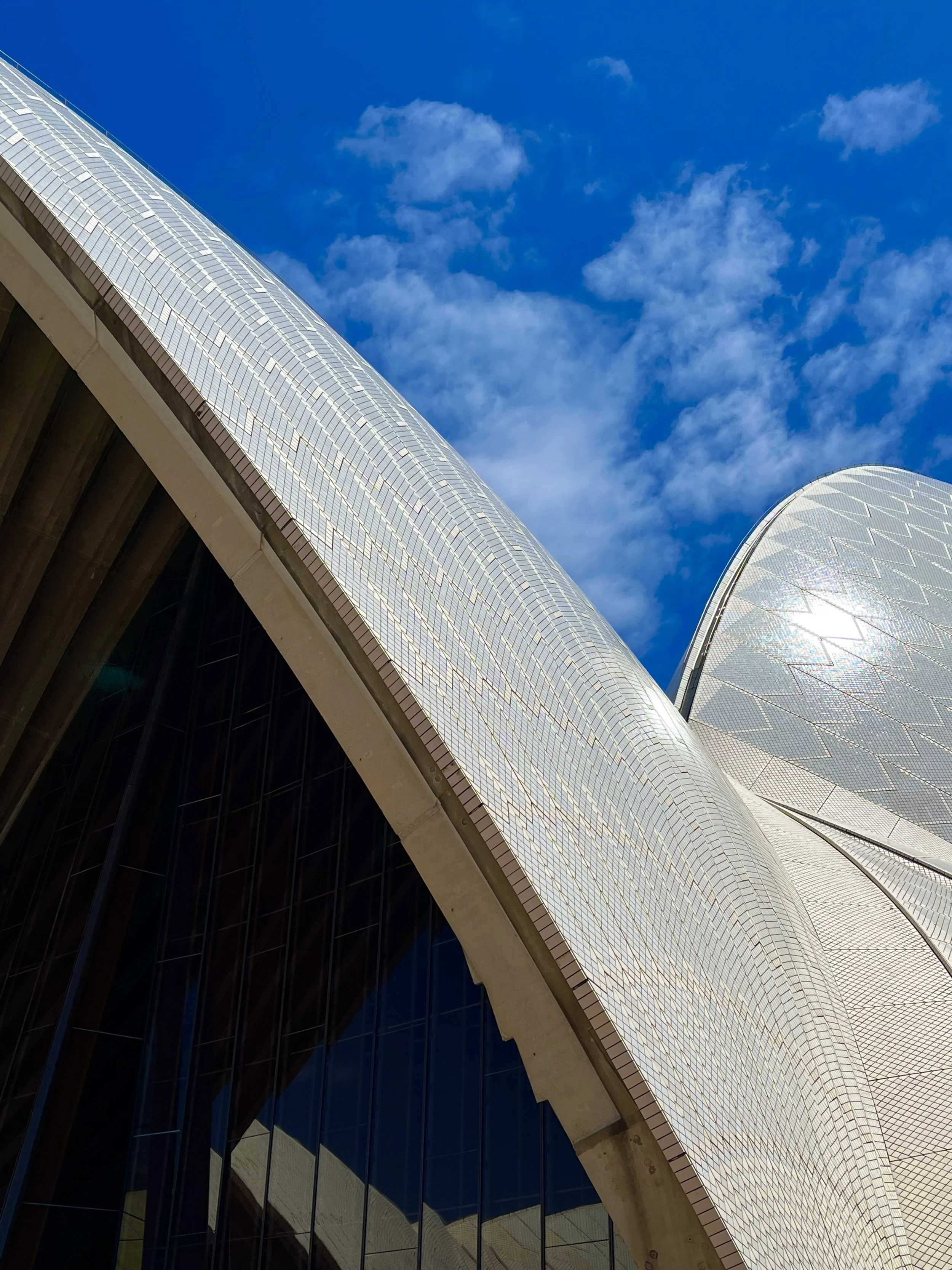 Detail of the Sydney Opera House sails against a blue sky.