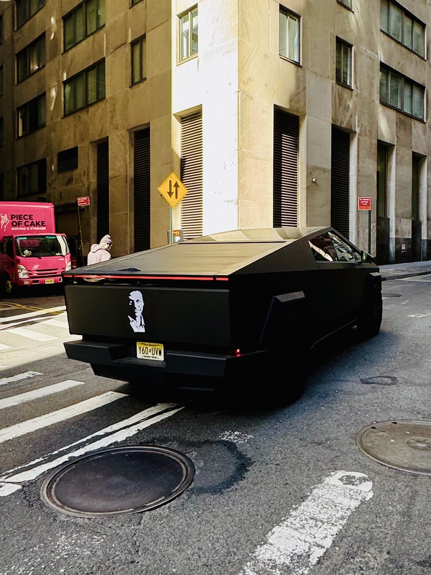 Matte black futuristic truck in urban setting with buildings