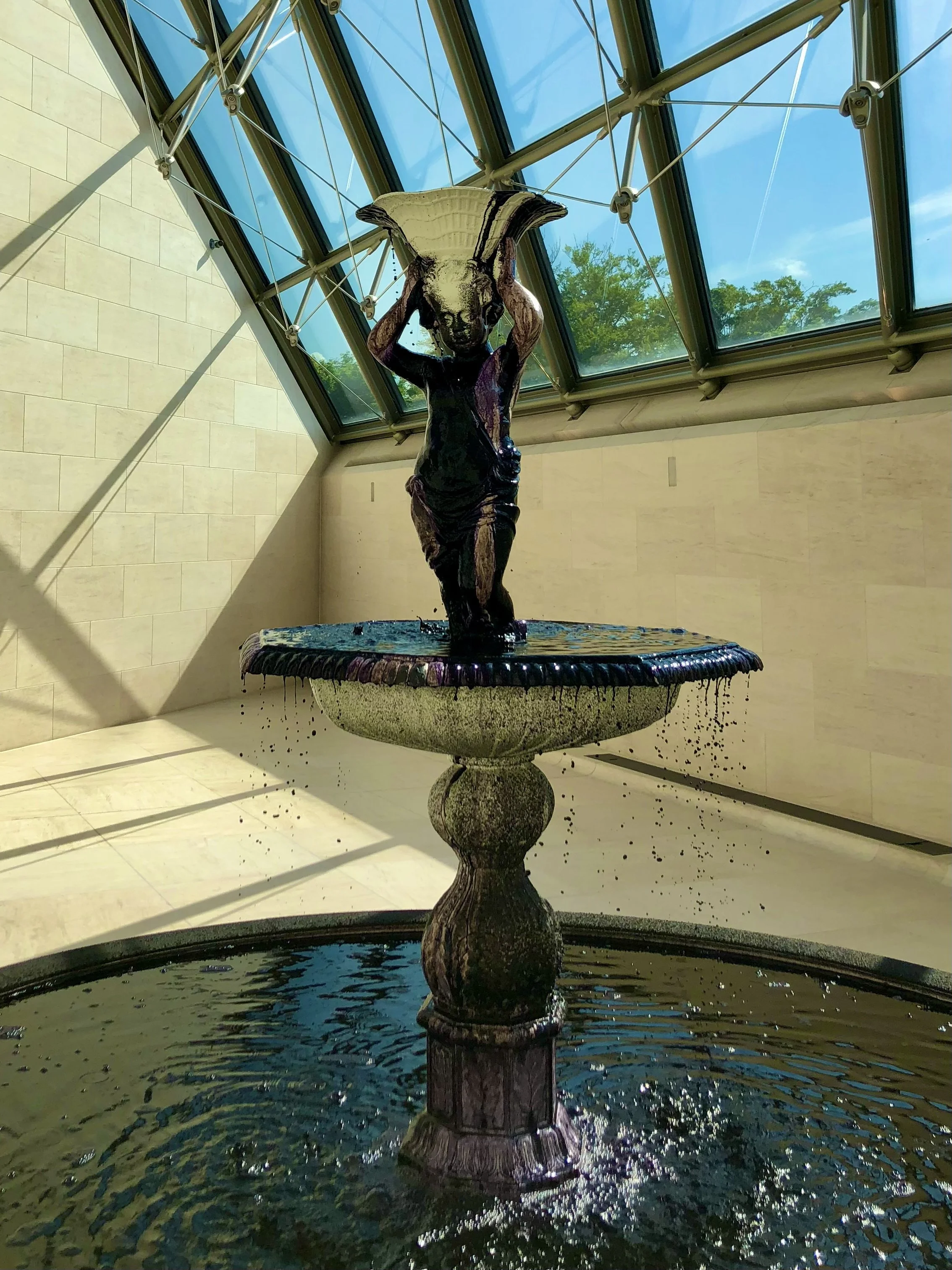 Indoor fountain with sculpture under glass ceiling
