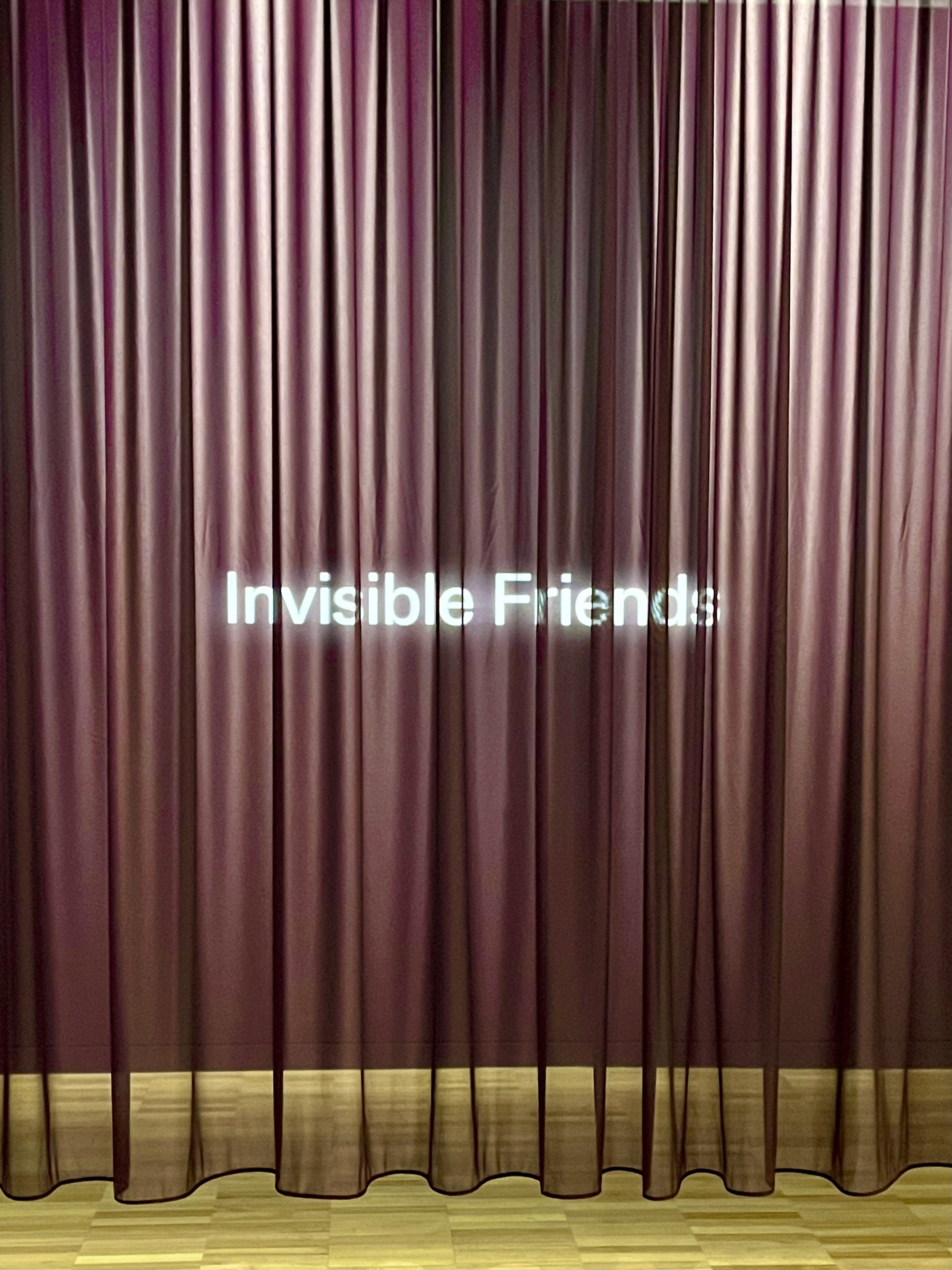 Purple curtain with 'Invisible Friends' text