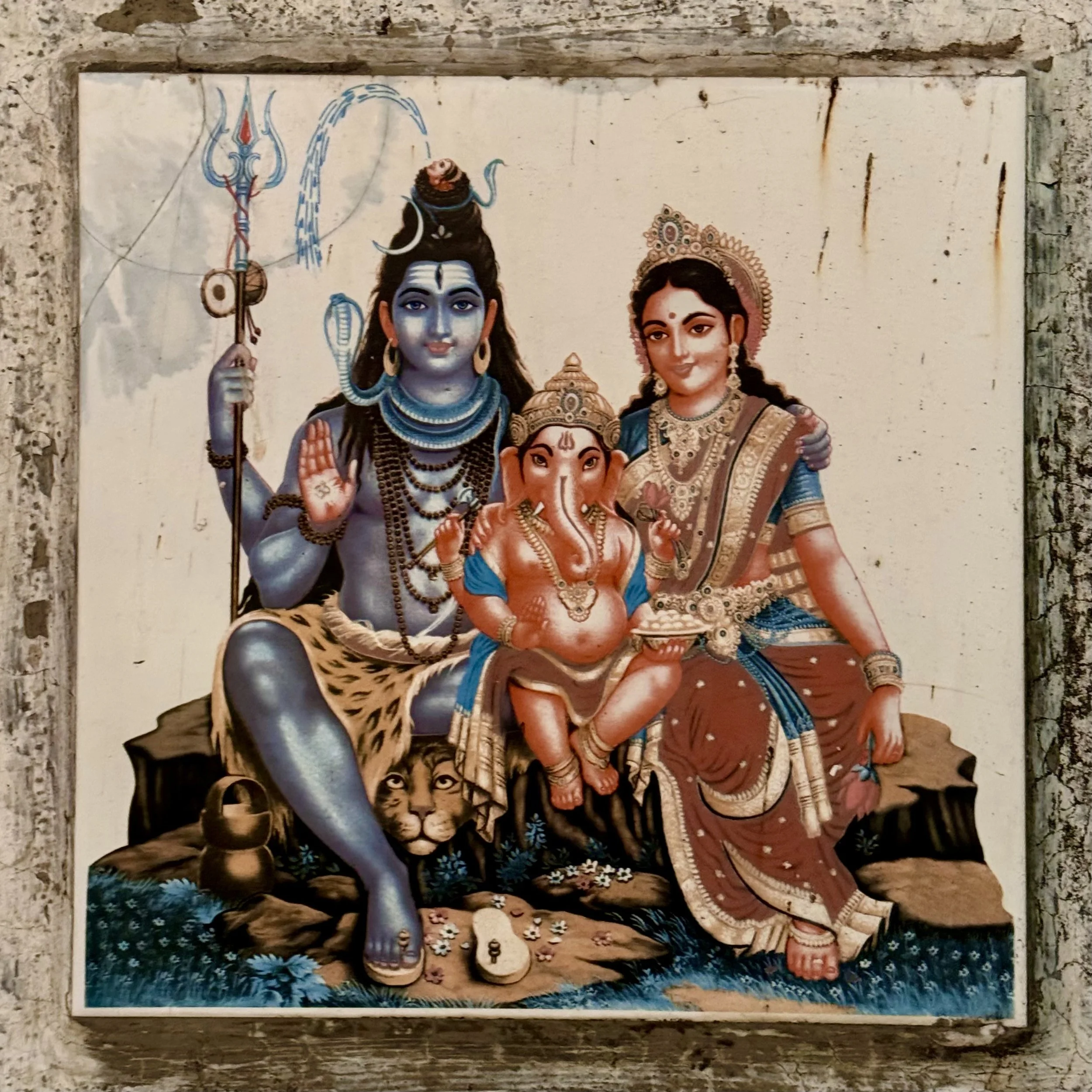 Hindu deities Shiva, Parvati, and Ganesha in a painting on a wall.