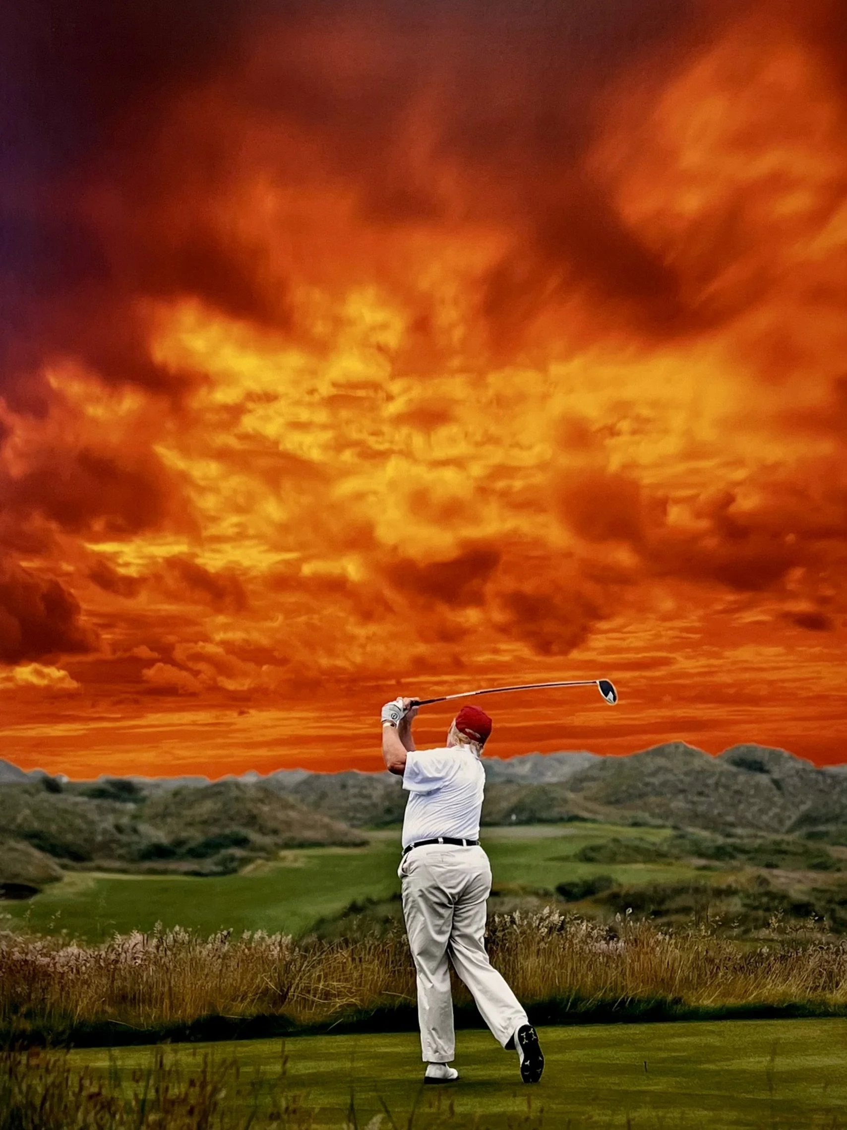 Golfer in white outfit and red hat swinging a club on a golf course, with vibrant orange and red sky in the background.