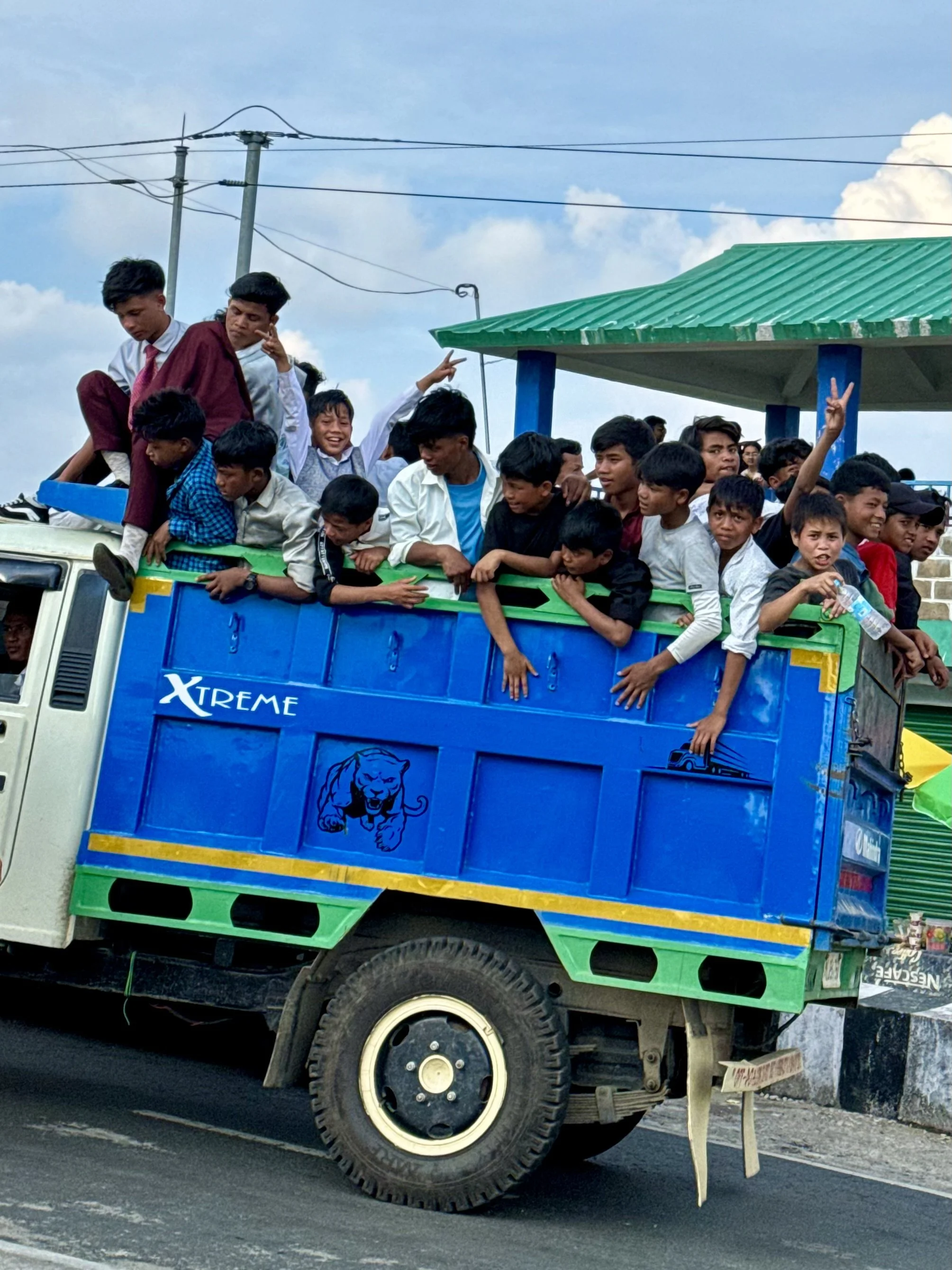 Group of people crowded on a blue truck with "Xtreme" logo.