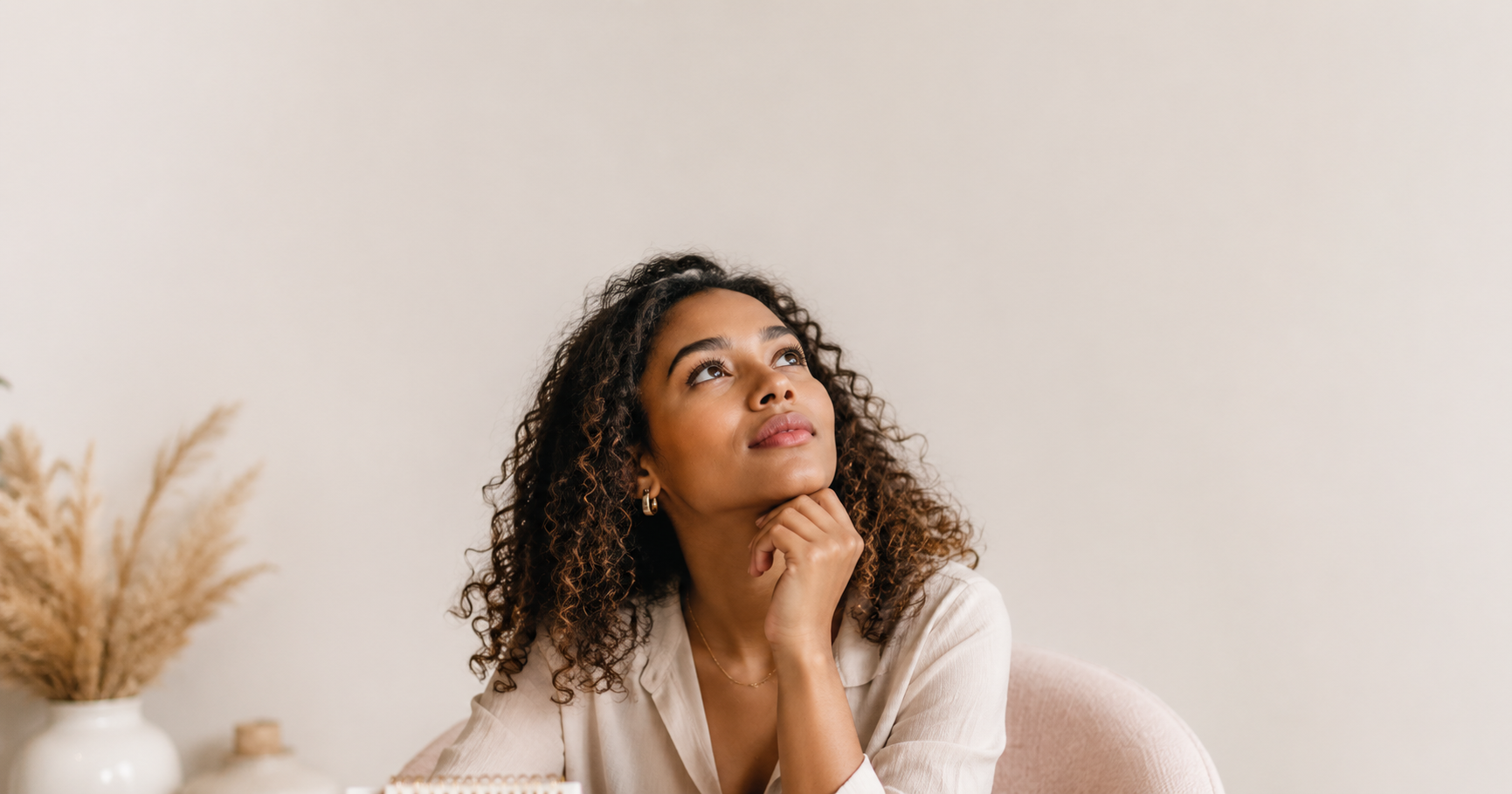 Afro-Latina woman looking upward in thoughtful reflection, symbolizing self-awareness, personal growth, and learning how to stop self-sabotaging.