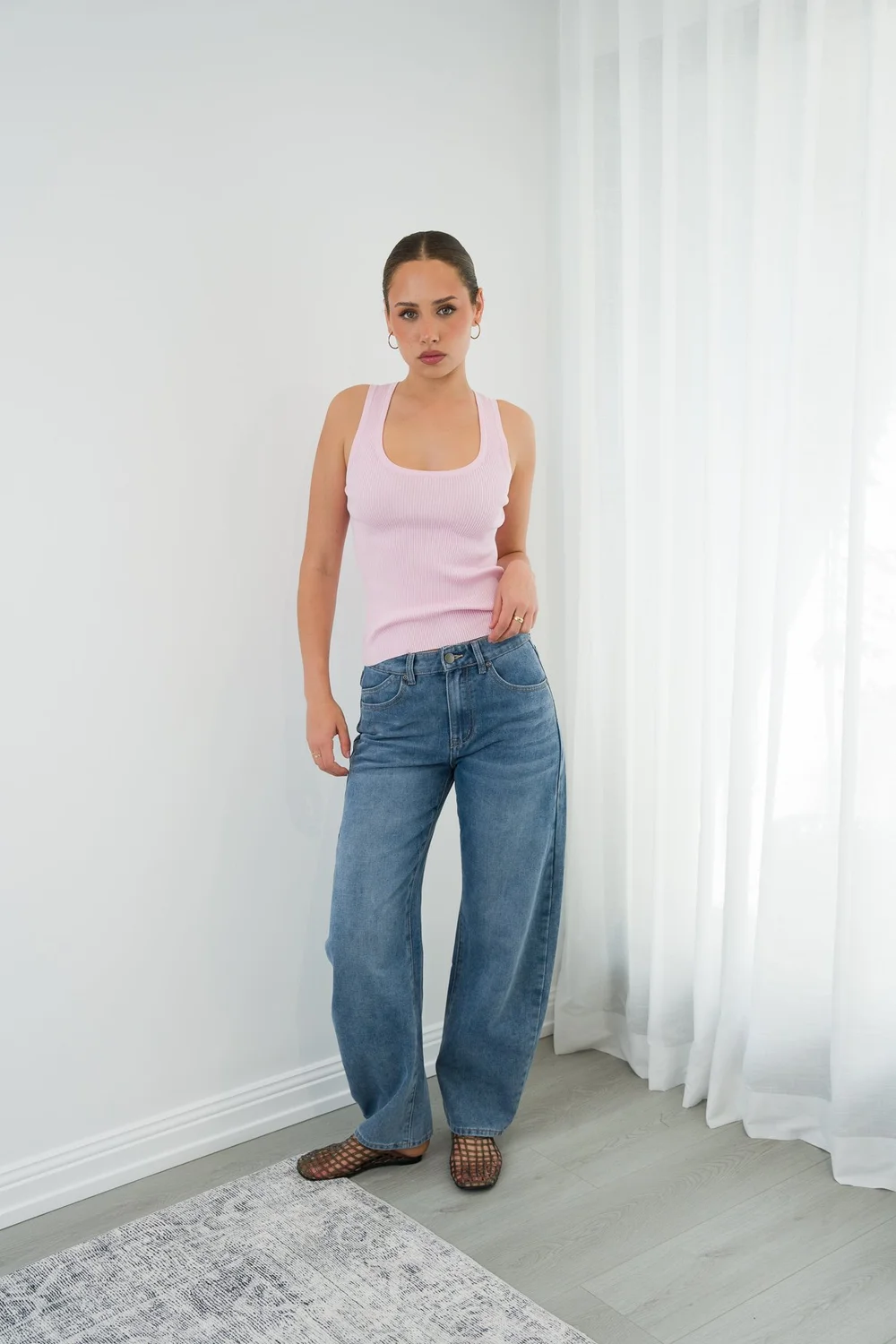 Model in denim by the curtains