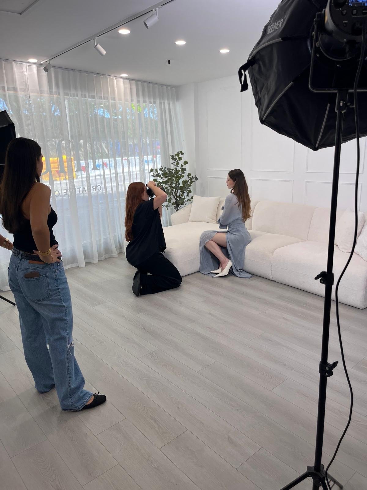 Photographer shooting a seated model by the studio windows