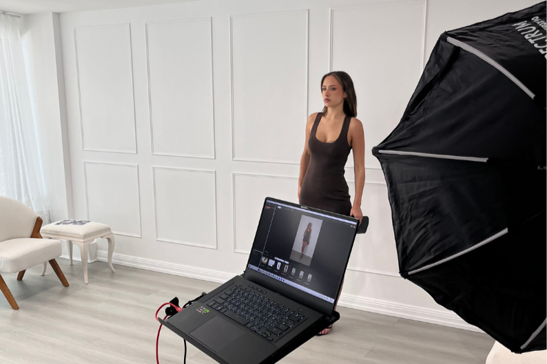 Woman shooting content against a white panelled wall