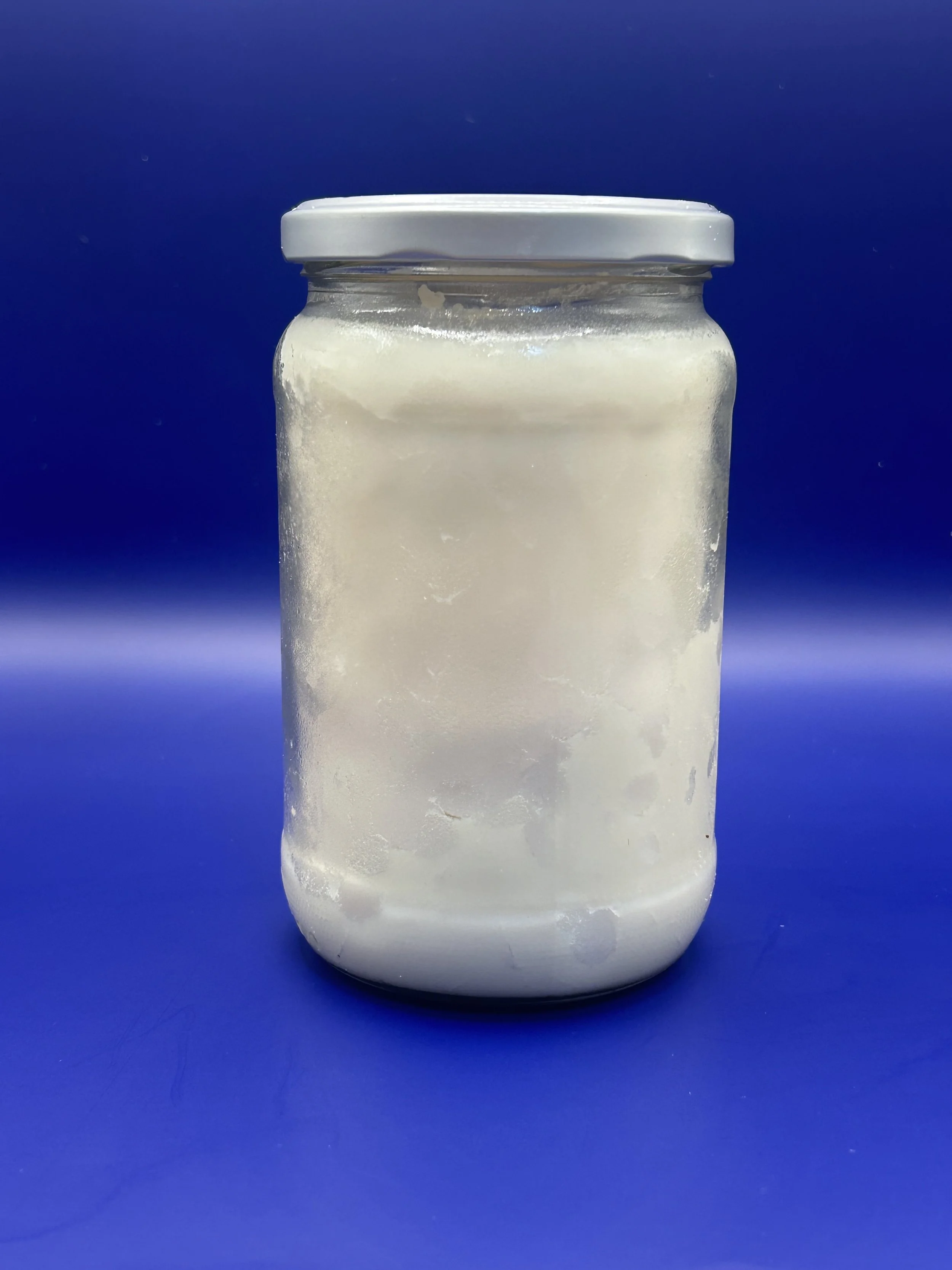 A jar of lard against a blue background
