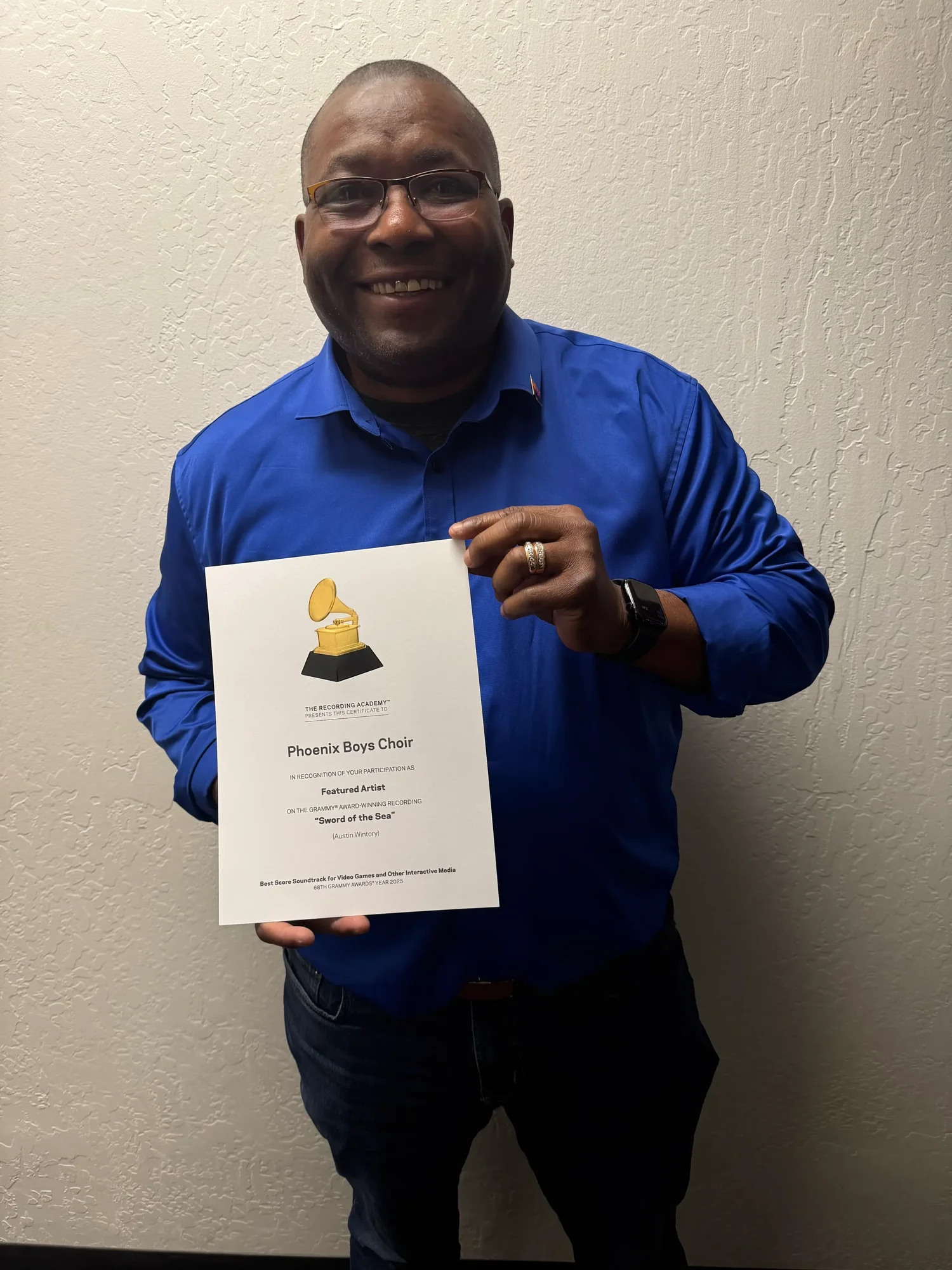 Dr. Neal smiling while holding a certificate