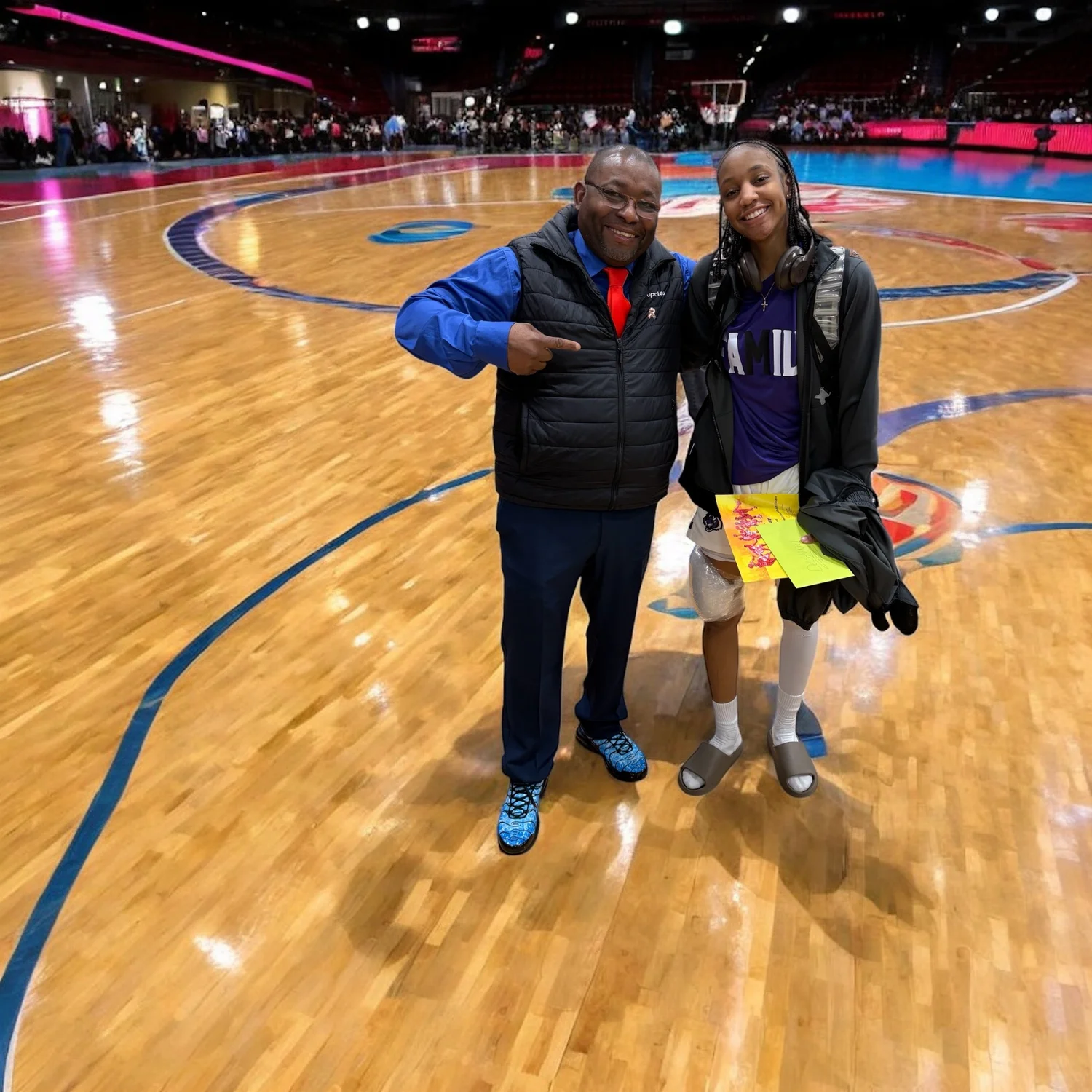 Dr. Neal and a young person standing together on a basketball court