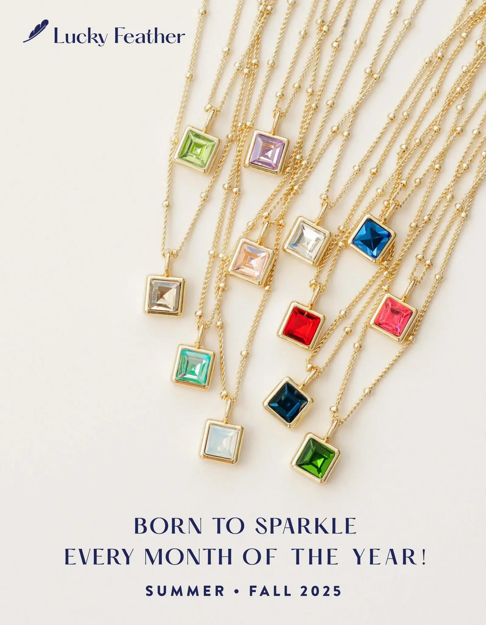 Elevated flat lay product photography of a jewelry advertisement featuring gold necklaces with colorful square birthstone pendants on a cream backdrop.