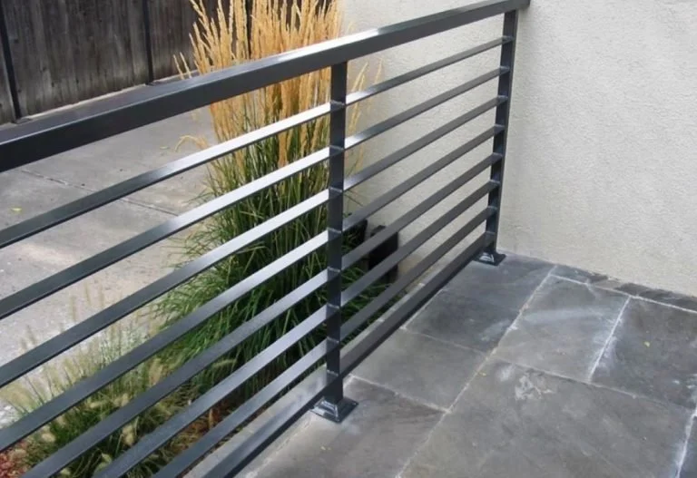 Barandilla moderna negra sobre un suelo de baldosas 